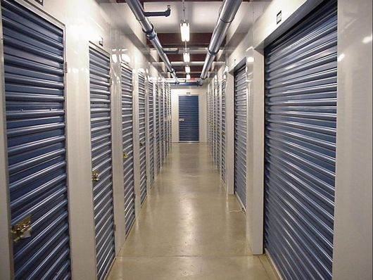Storage unit hallway with blue metal doors.