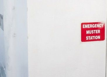 A white door with a red emergency muster station sign on it. LIFECELL products