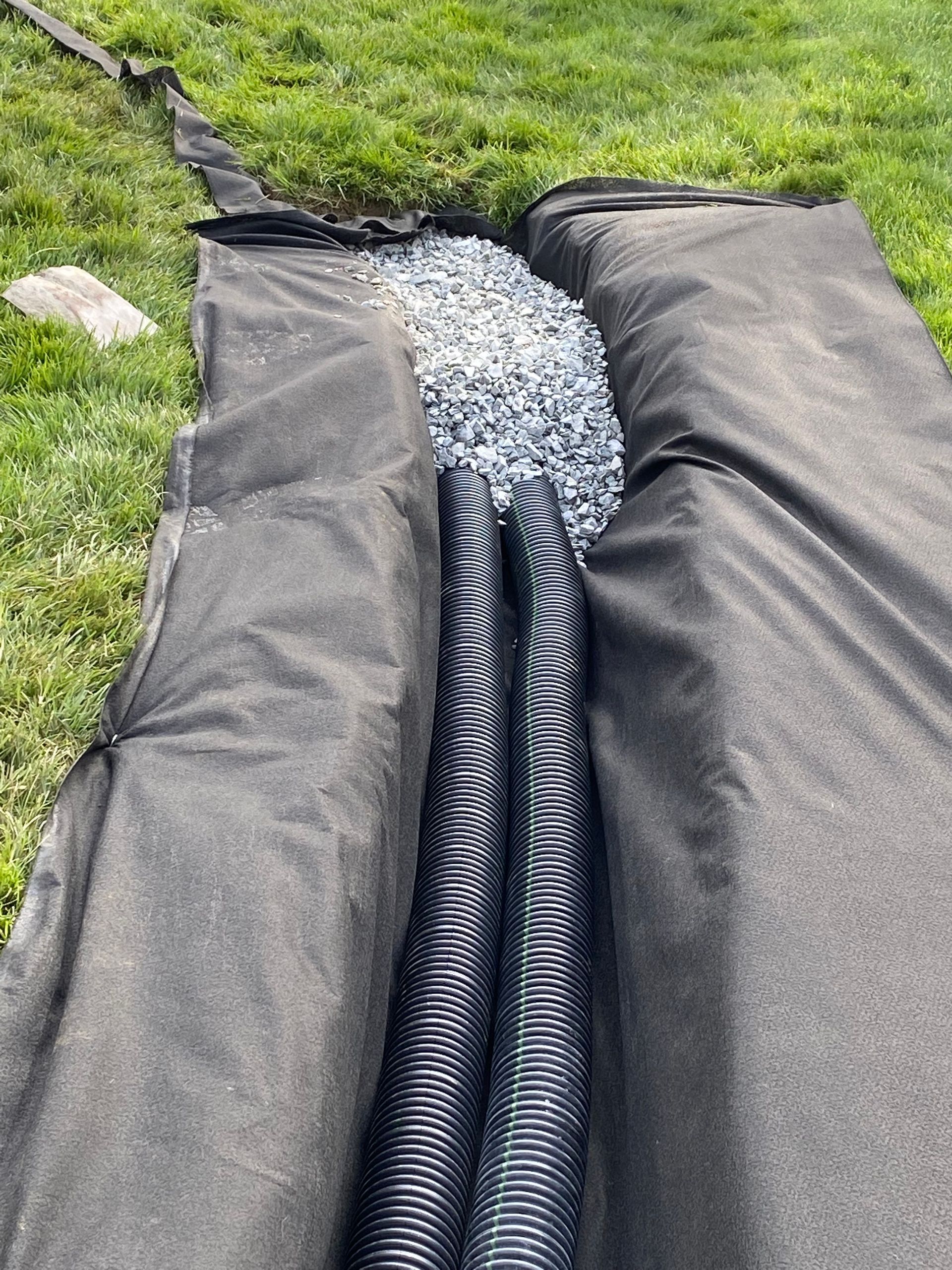 A drainage system is being installed in a yard.