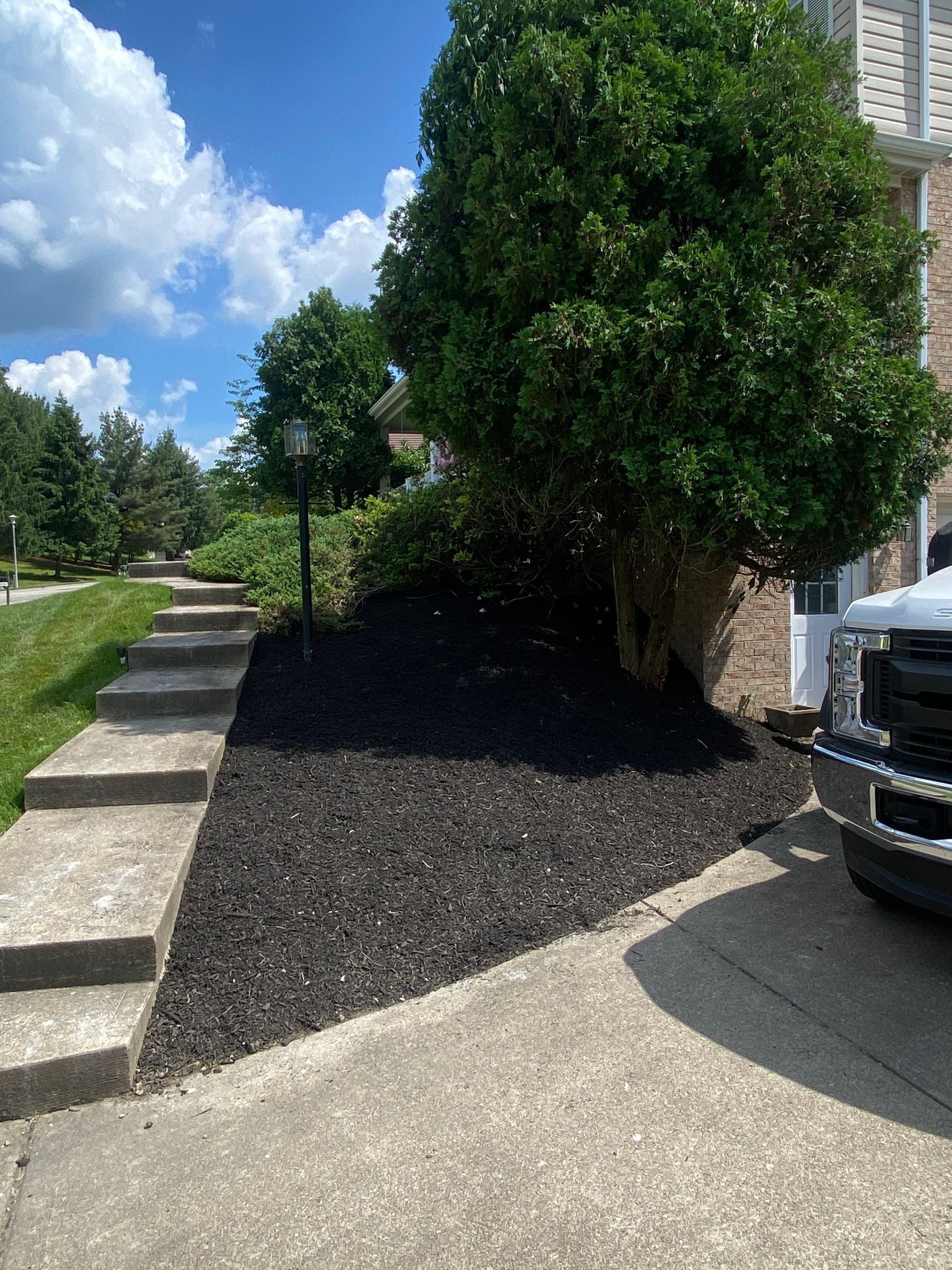A truck is parked in a driveway next to a house.