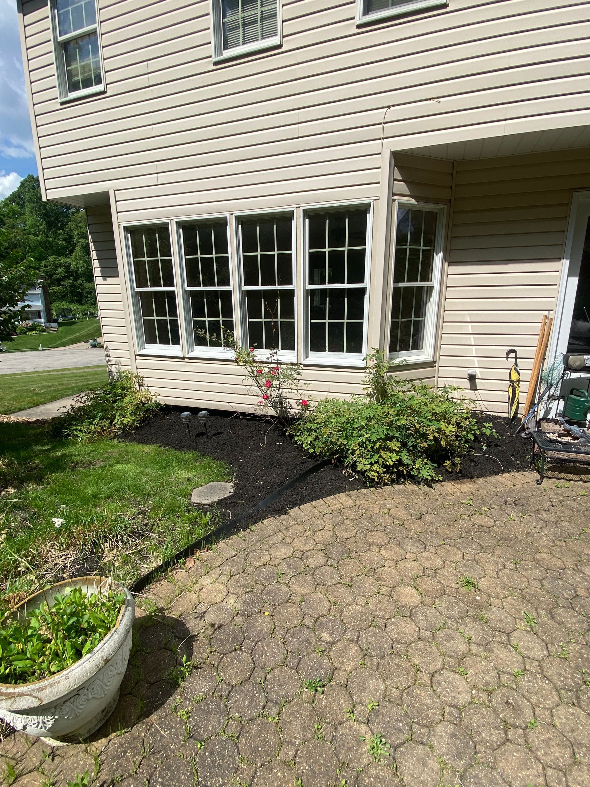 A house with a lot of windows and a patio in front of it.