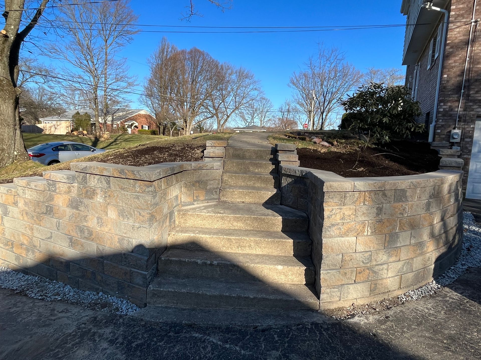 A stone wall with stairs leading up to a house.