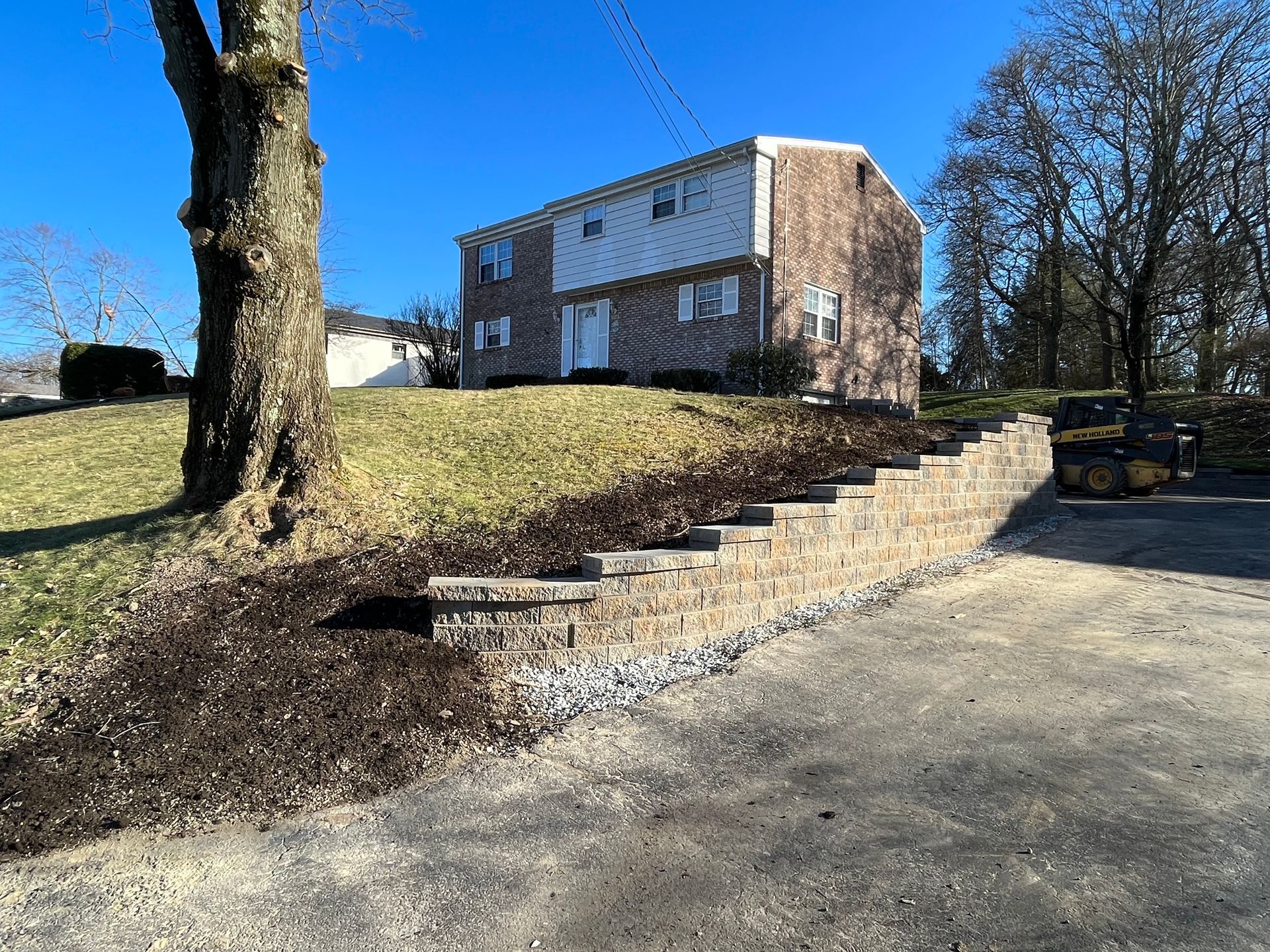 A house with stairs leading up to it and a tree in front of it.