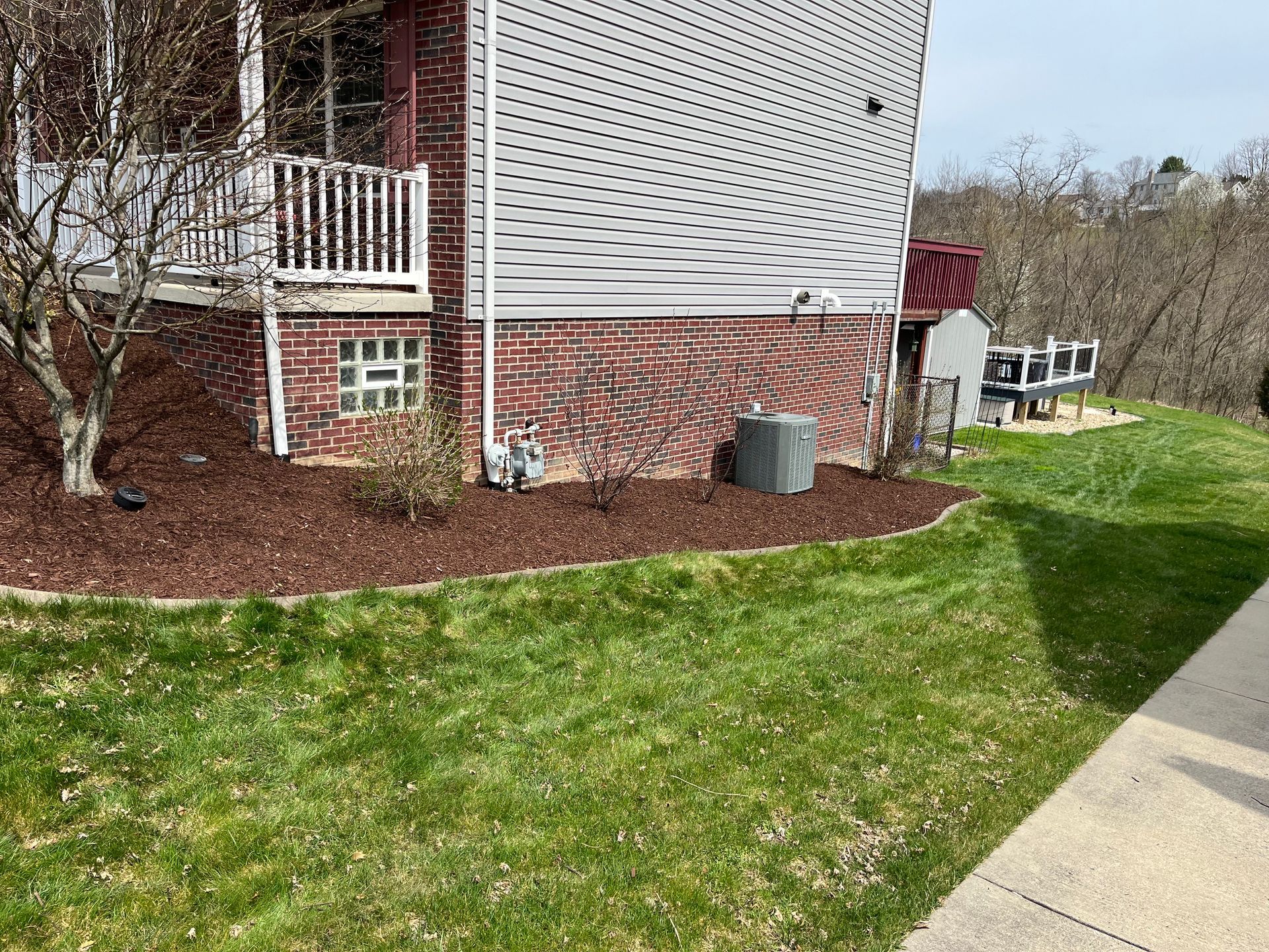 A house with a large lawn and a sidewalk in front of it.