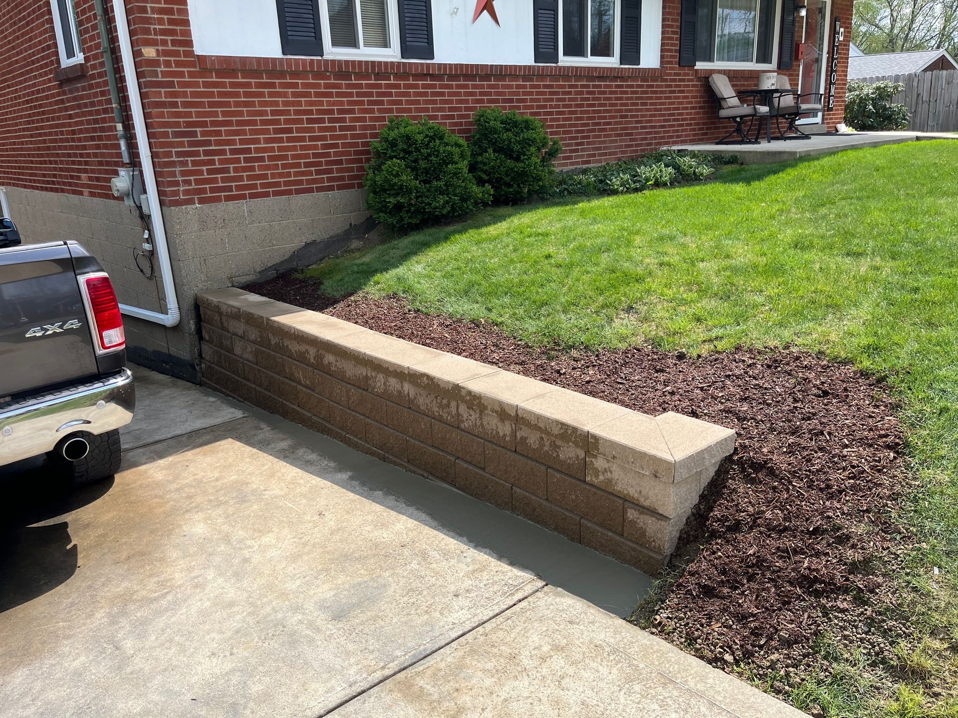 A truck is parked in front of a brick house.