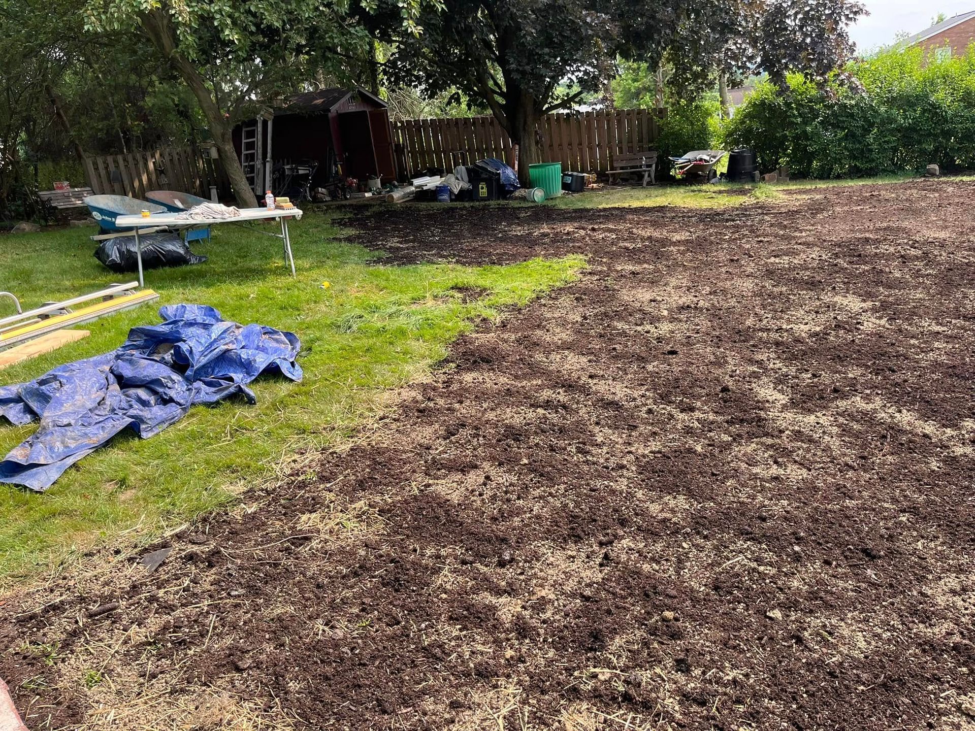 A large pile of dirt is sitting on top of a lush green lawn.