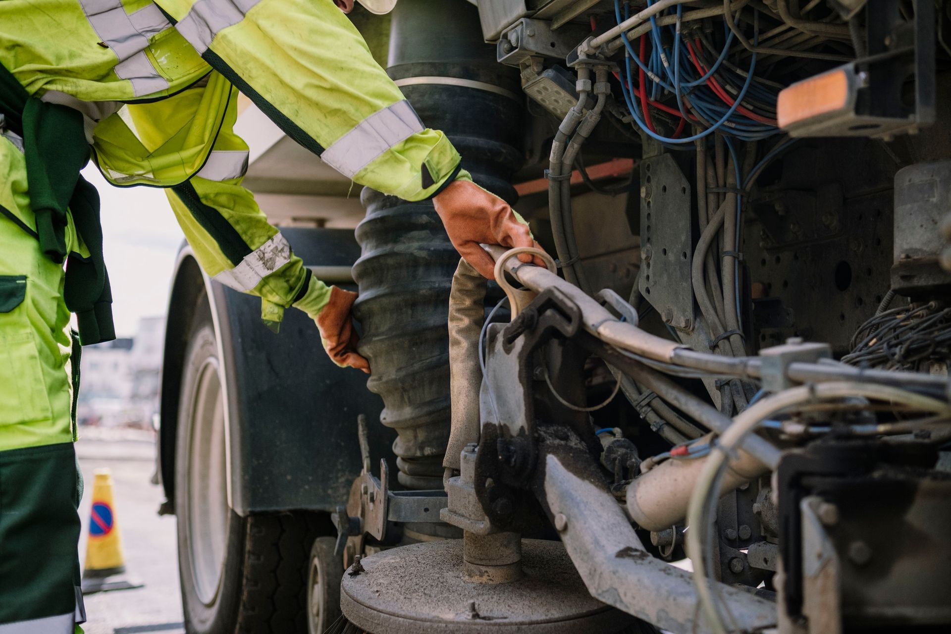 White semi-truck driving on a paved road, red accents on the cab, trees in the background.