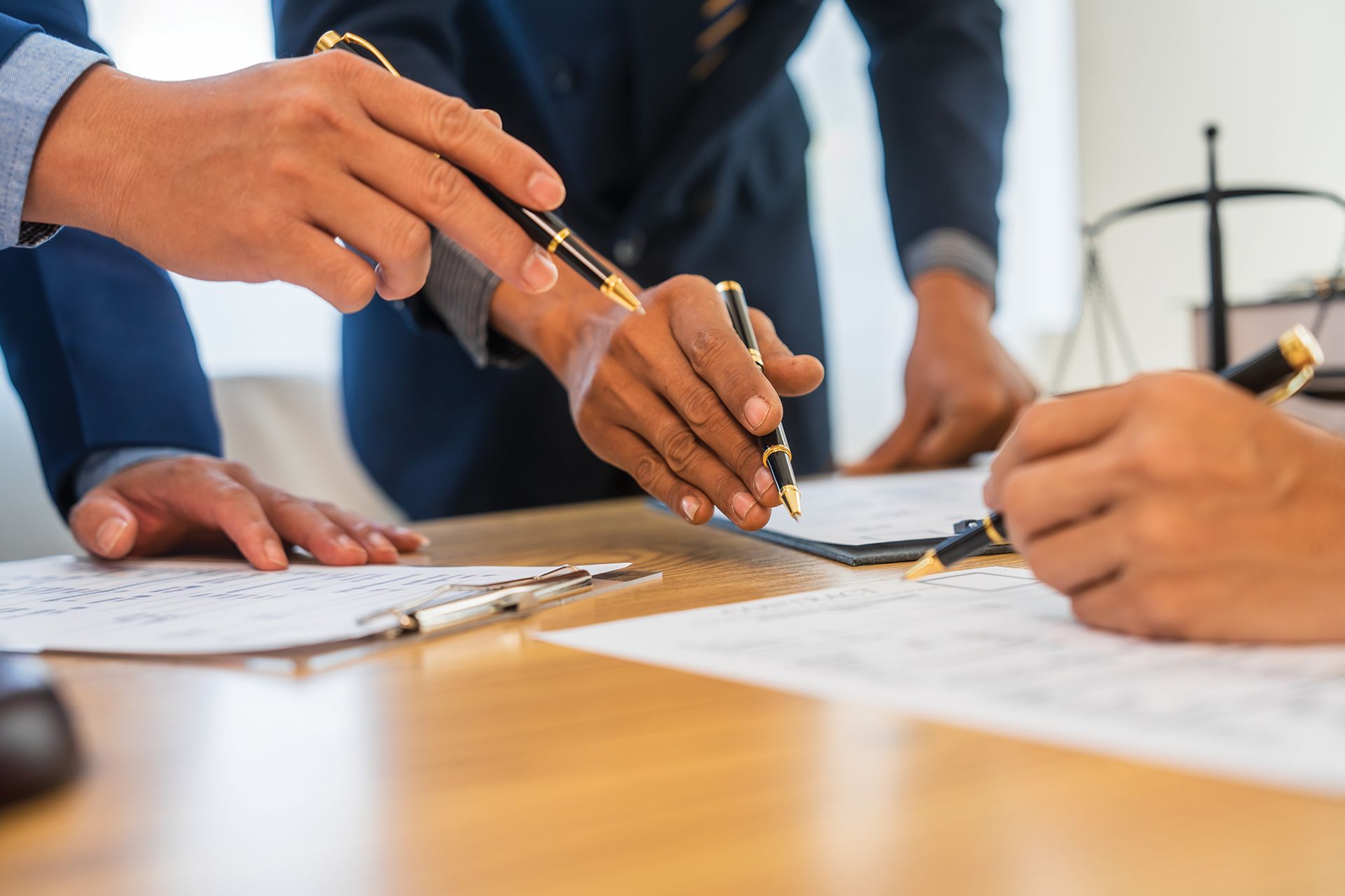 Two Men Are Sitting at a Table With a Gavel and Scales of Justice