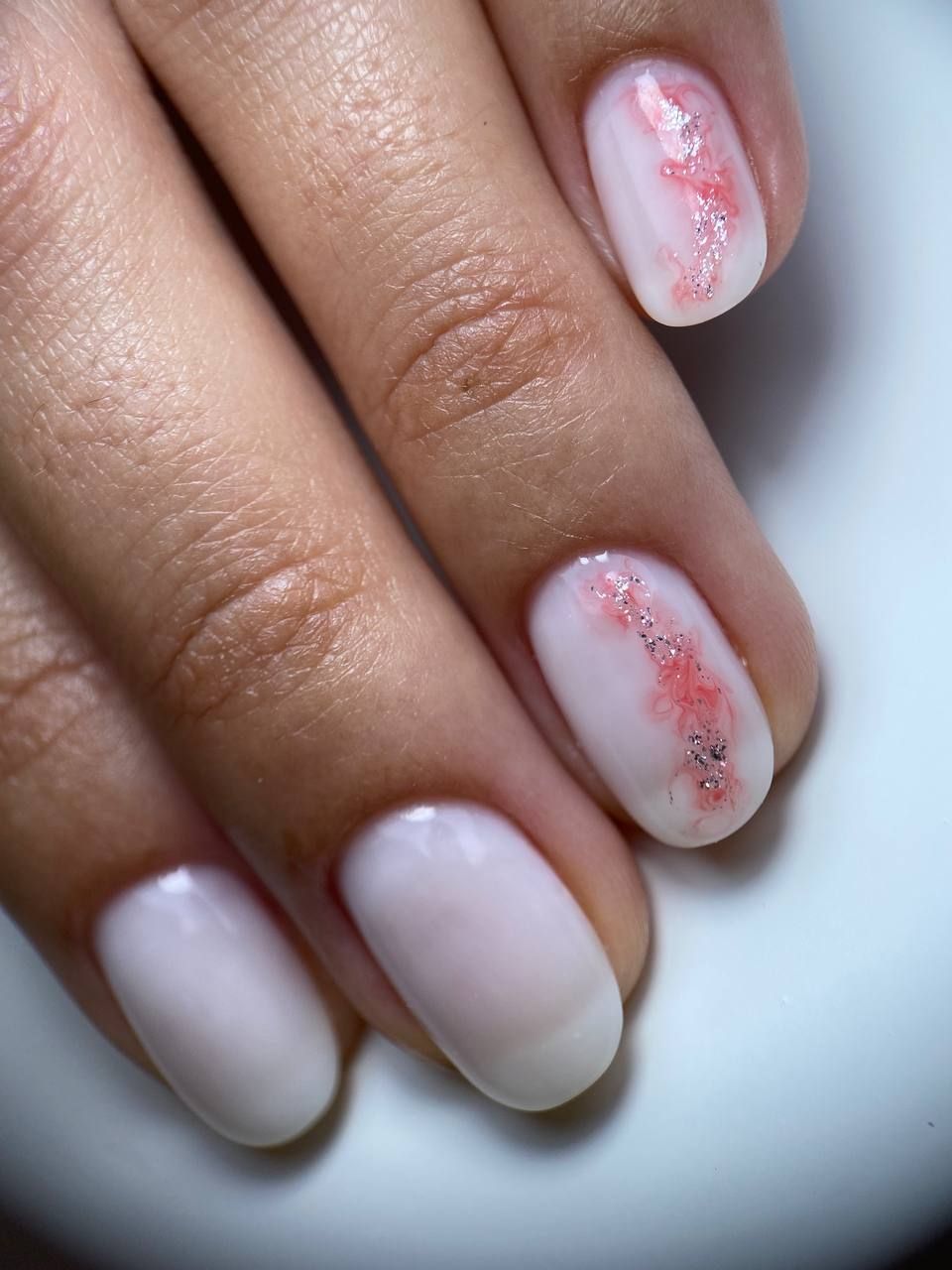 unghie con smalto chiaro e decorazione floreale