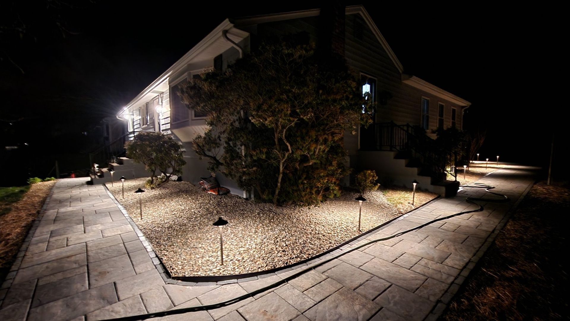 A house is lit up at night with a walkway leading to it