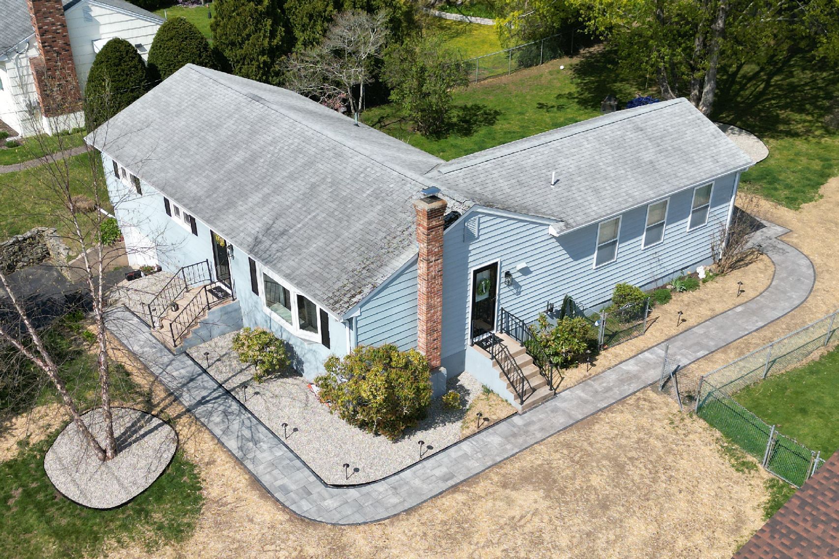 An aerial view of a house with a concrete walkway leading to it.