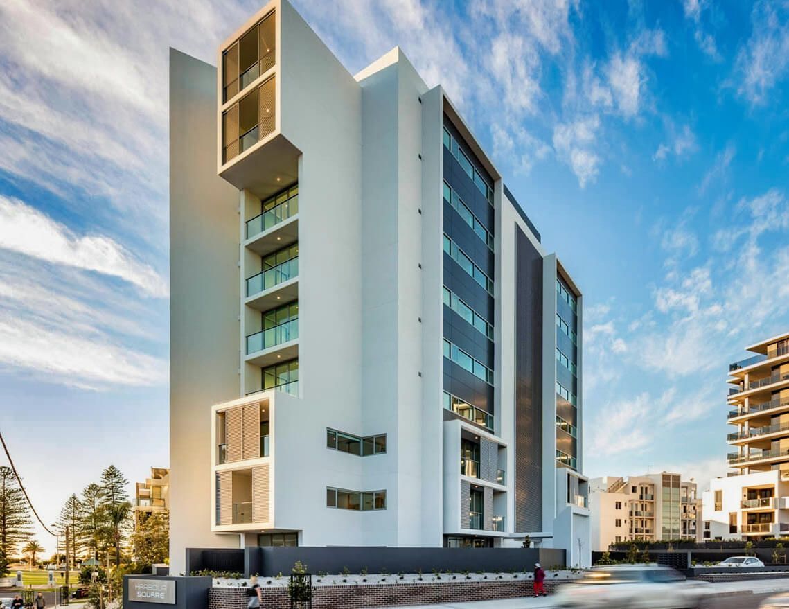 A Tall Building with A Lot of Windows and Balconies — Tony Di Milia Flooring in Unanderra, NSW