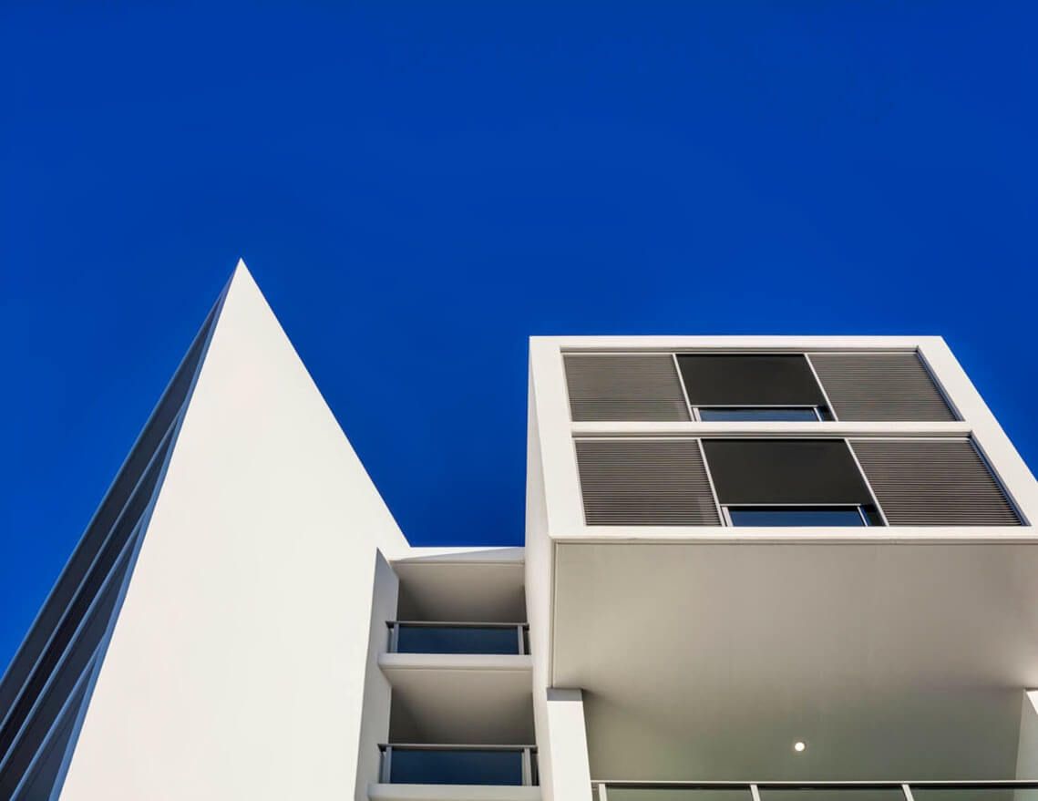 Looking up At a Building with A Blue Sky in The Background — Tony Di Milia Flooring in Unanderra, NSW