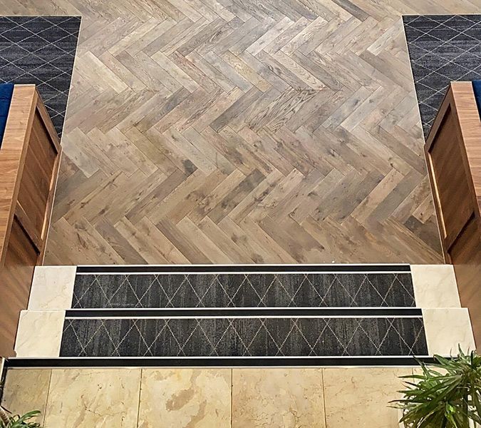Stairs Leading up To a Wooden Floor with A Herringbone Pattern — Tony Di Milia Flooring in Unanderra, NSW
