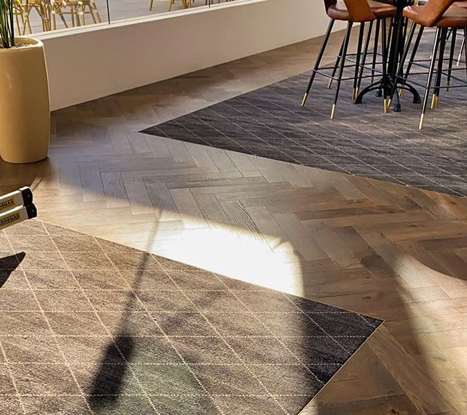 A Room with A Table and Chairs and A Rug on The Floor — Tony Di Milia Flooring in Unanderra, NSW