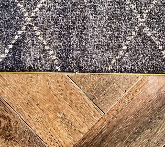 a close-up of a rug on a wooden floor — Tony Di Milia Flooring in Unanderra, NSW