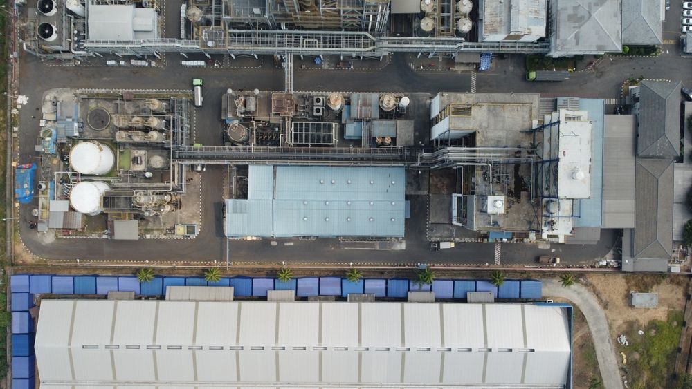 An aerial view of a large-scale industrial facility or factory. a complex network of metal pipes, ta