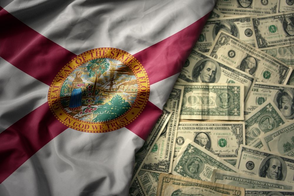 The flag of florida is laying on top of a pile of money.