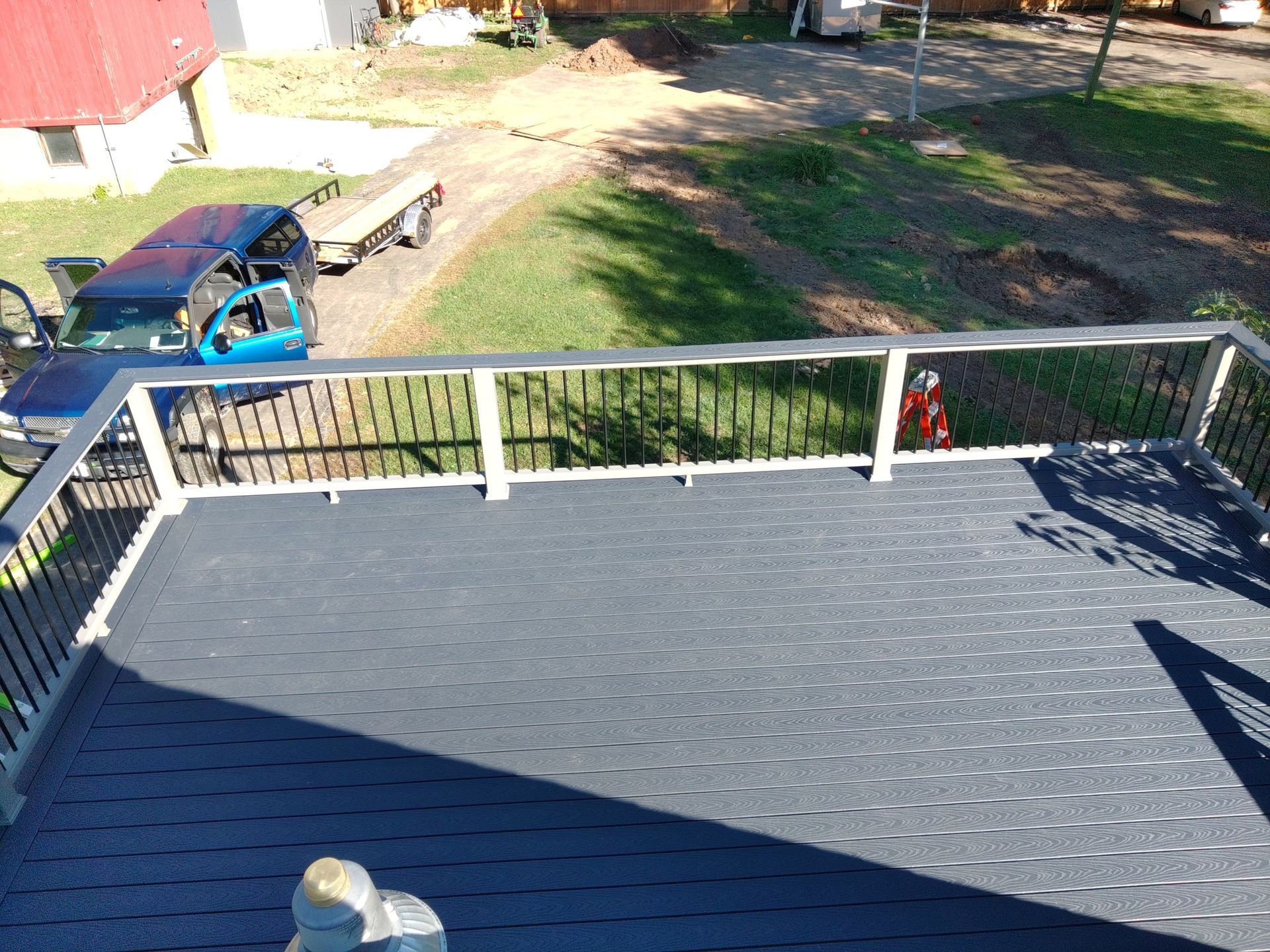 An aerial view of a deck with a railing and a truck in the background.