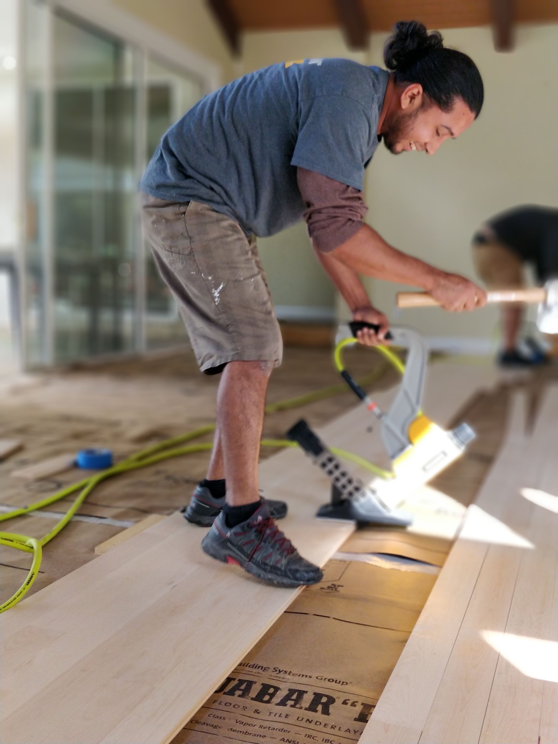 A man is working on a wooden floor