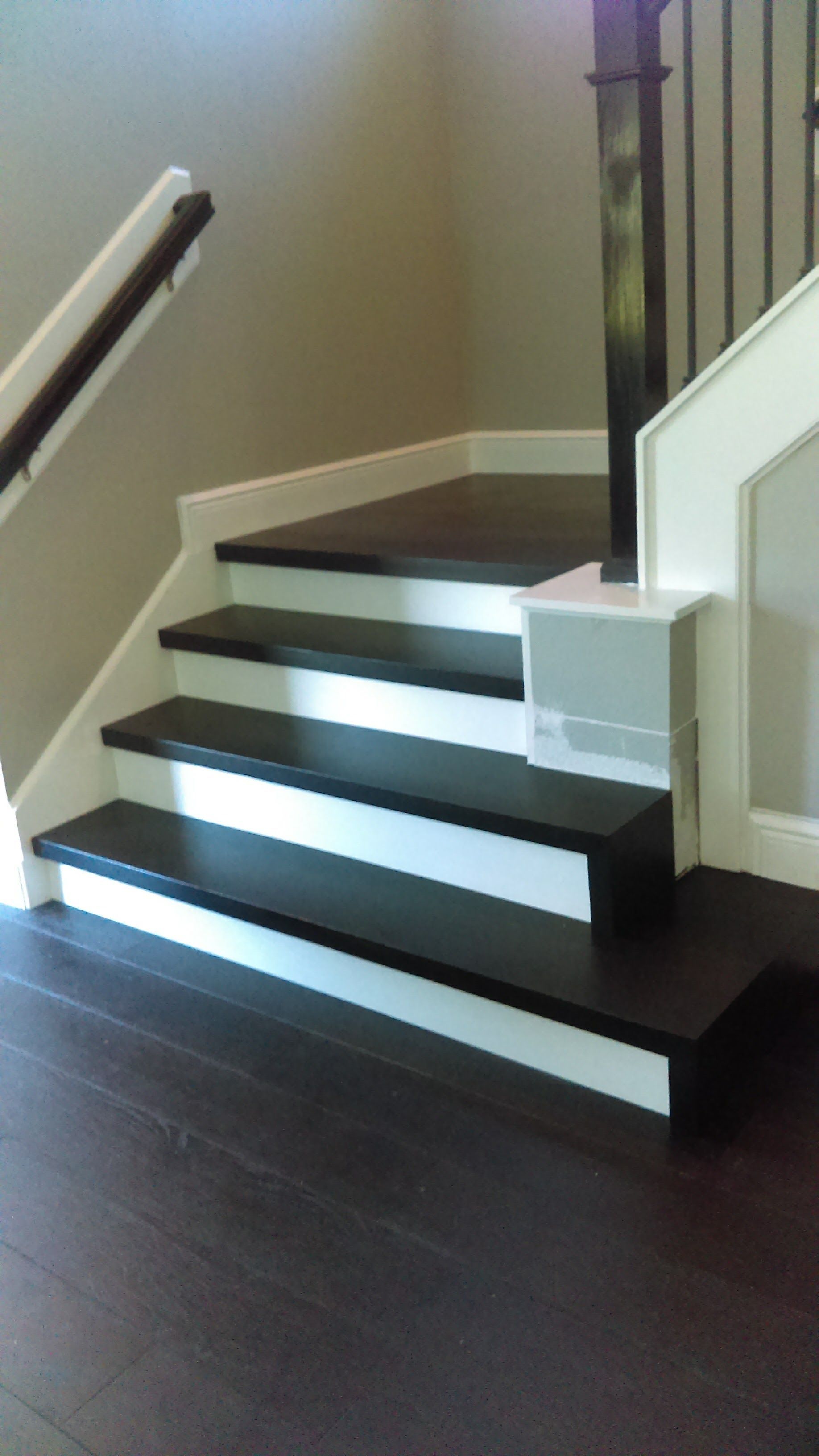 A set of black and white stairs with a white railing