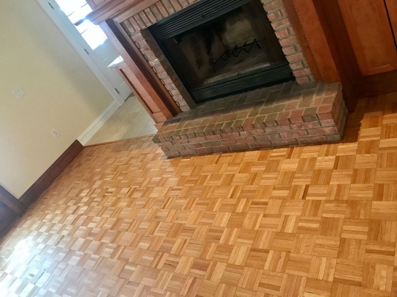 A living room with a fireplace and a wooden floor