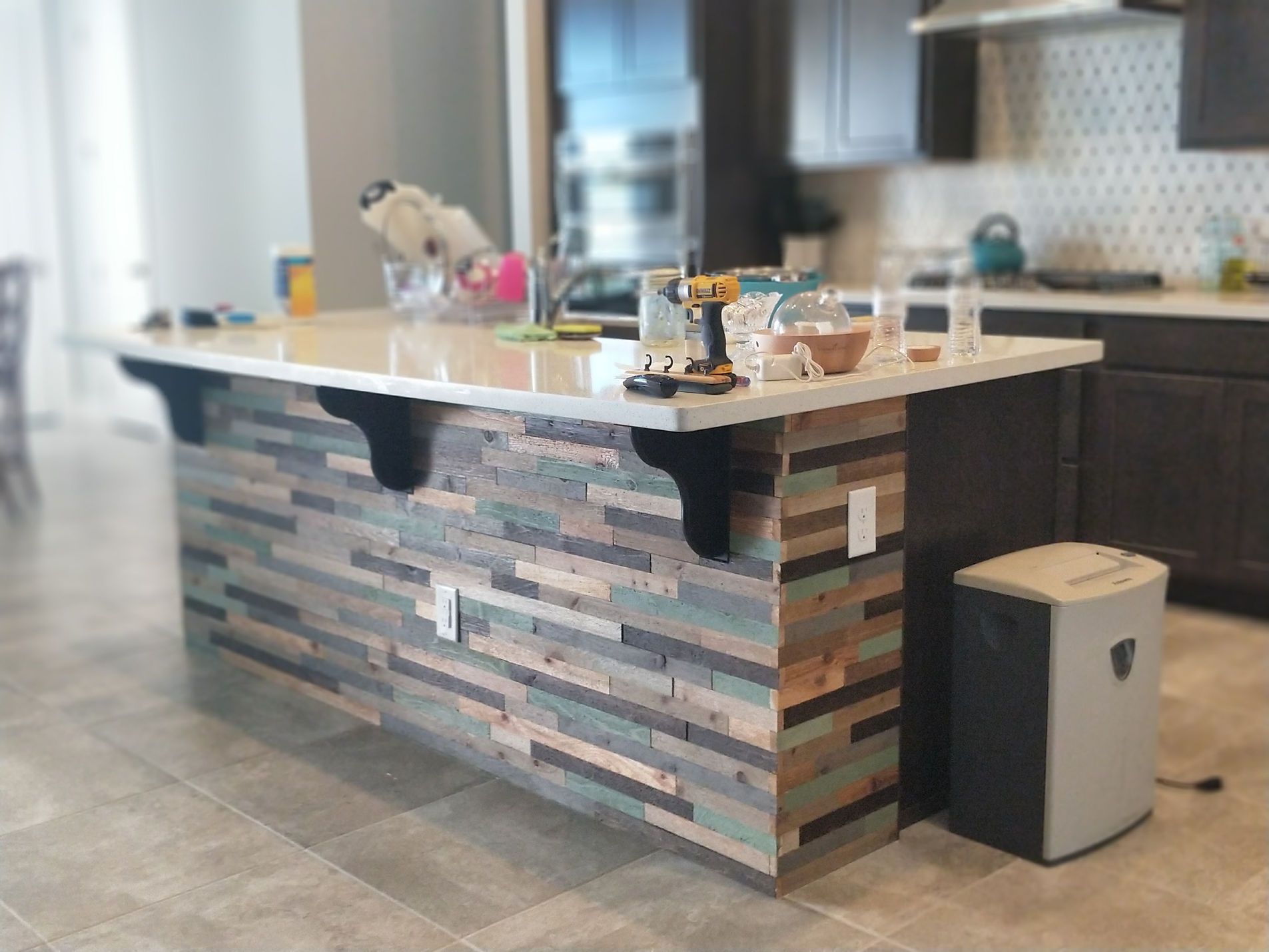 A kitchen with a wooden island and a trash can