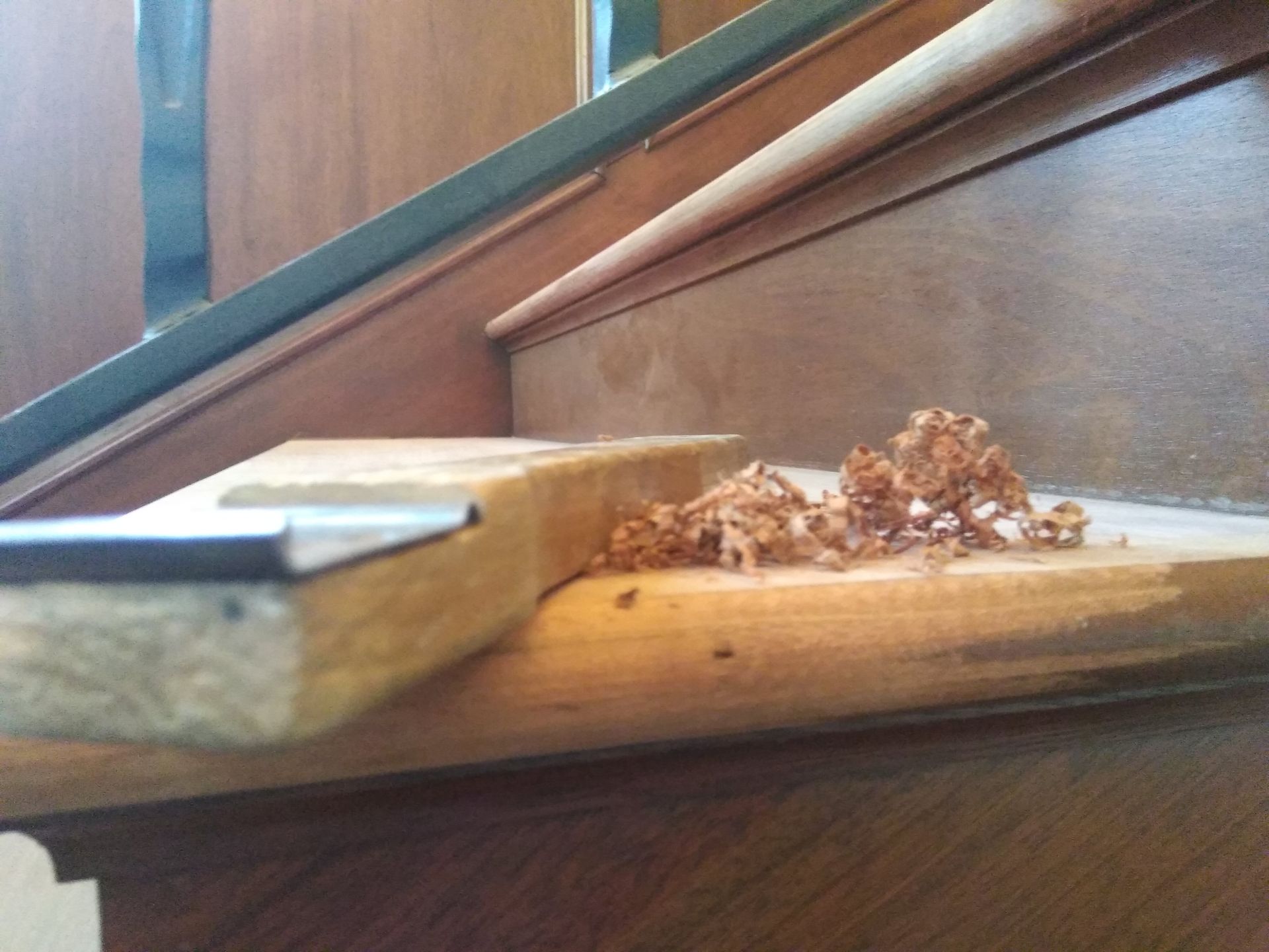 A piece of wood is sitting on top of a wooden staircase