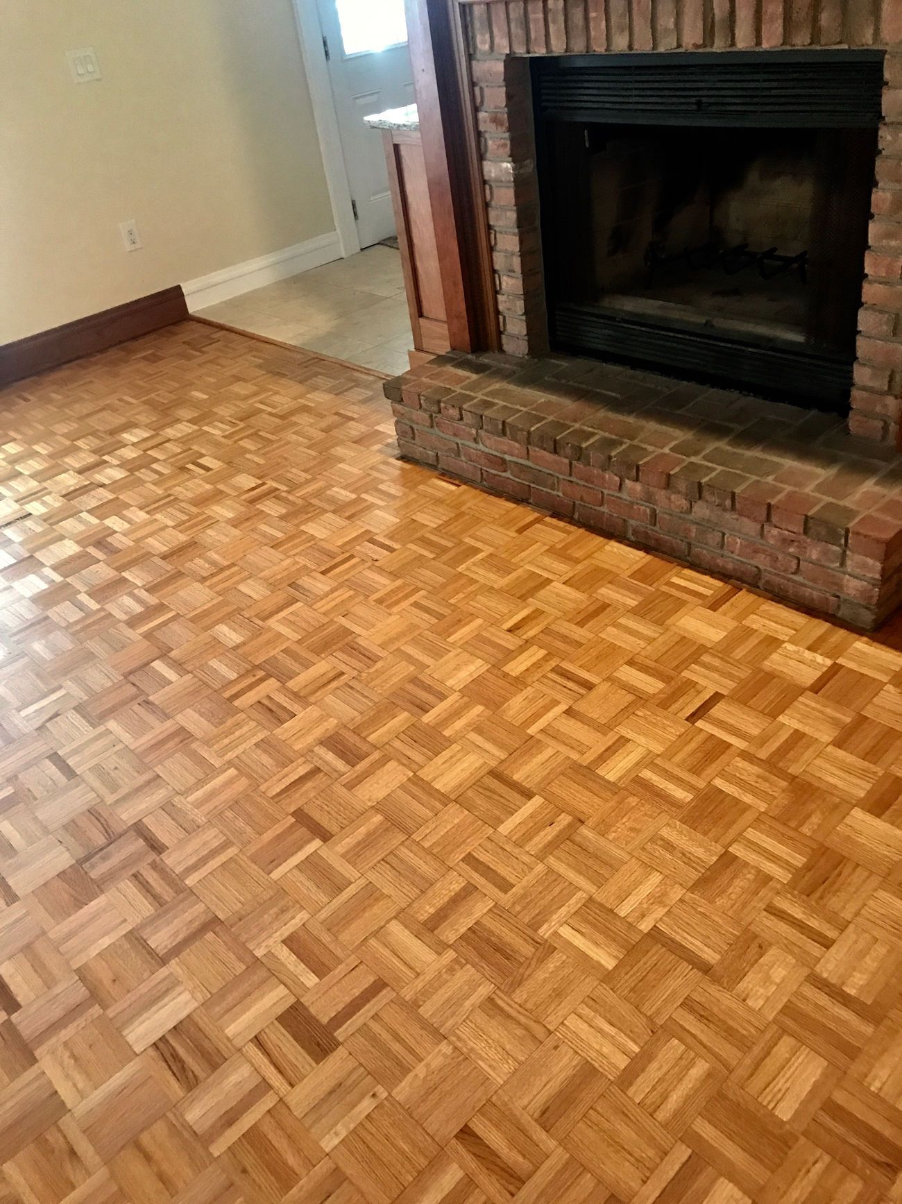 A living room with a wooden floor and a fireplace