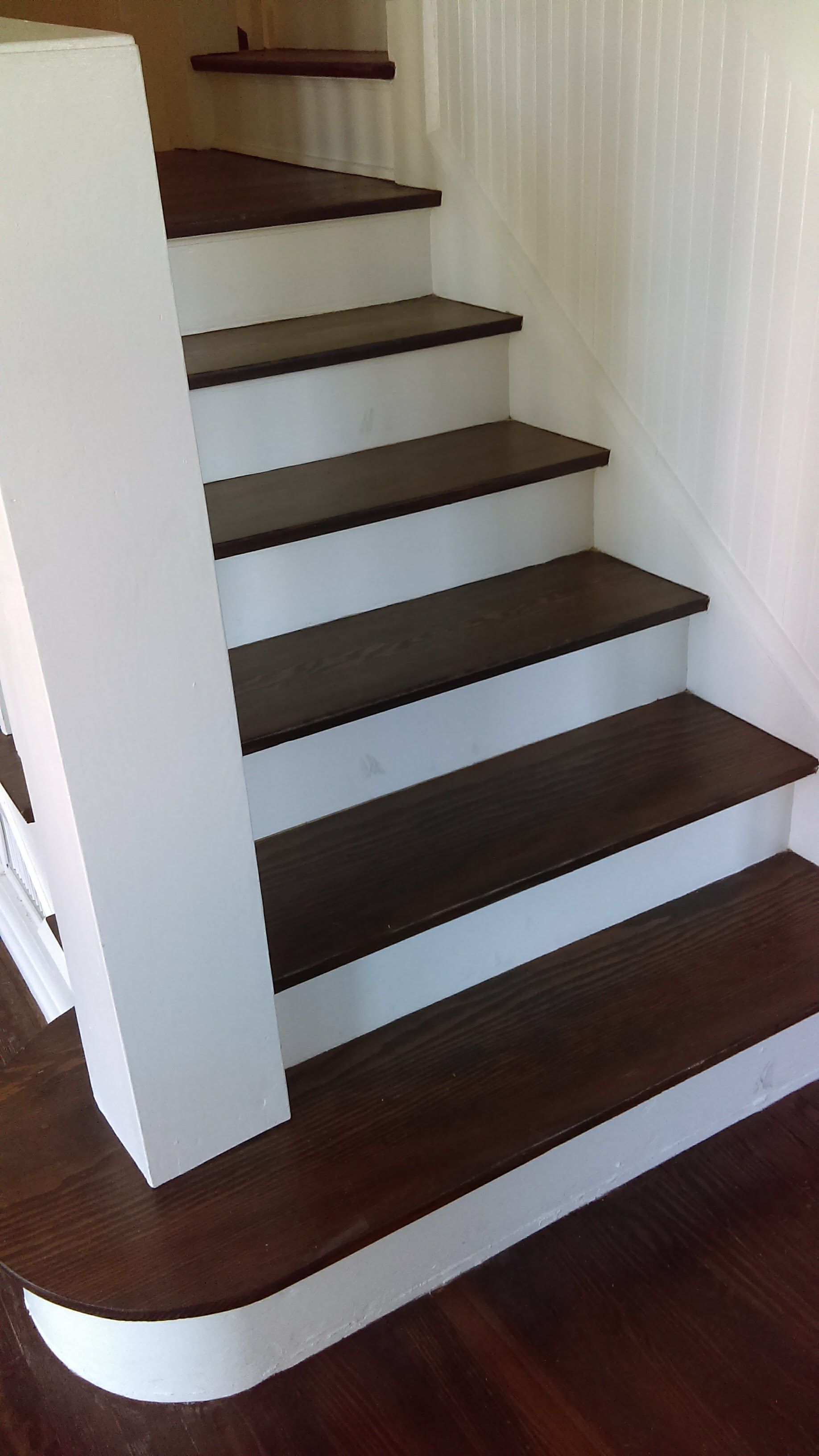 A staircase with wooden steps and white railing in a house.