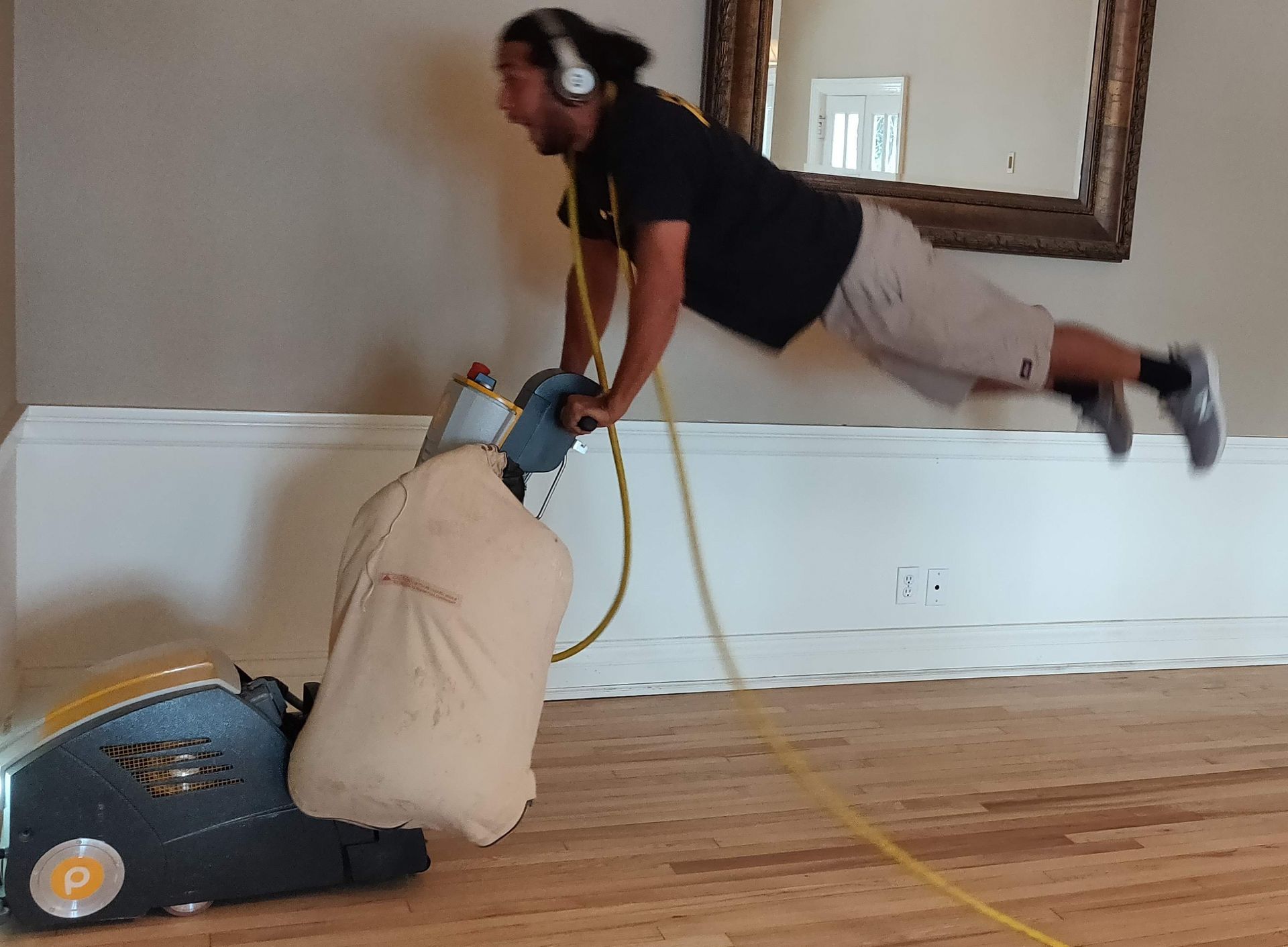 Man is sanding a wooden floor