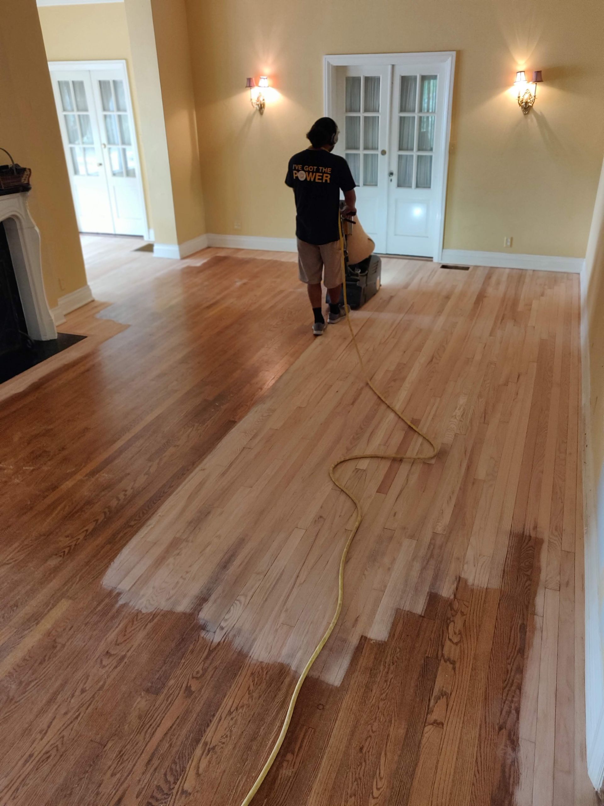 Sanding a wooden floor in a living room