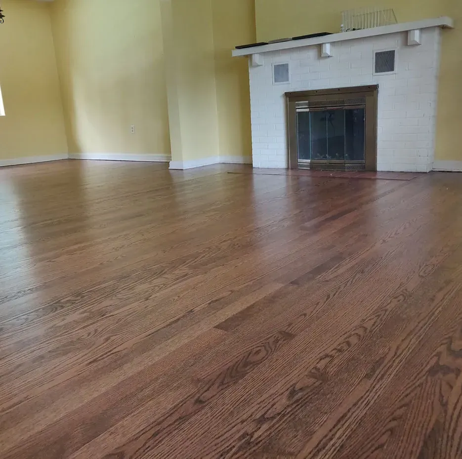 A living room with hardwood floors and a fireplace