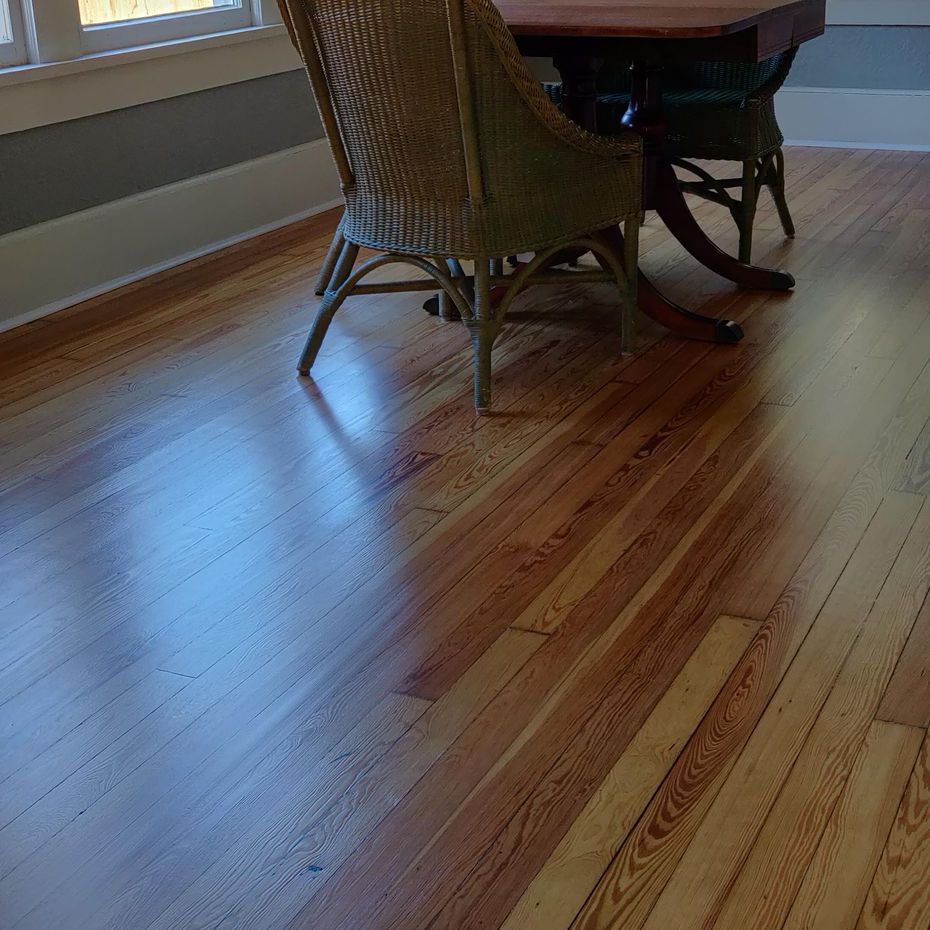 A wooden floor with a table and chairs on it