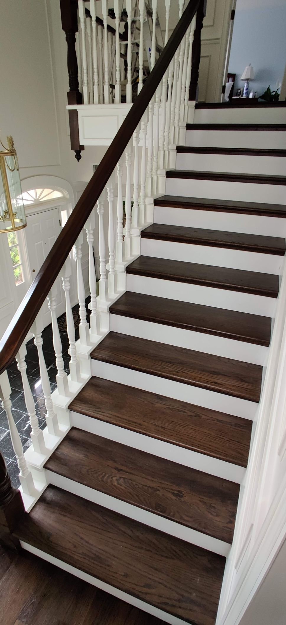 A staircase with wooden steps and white railing in a house