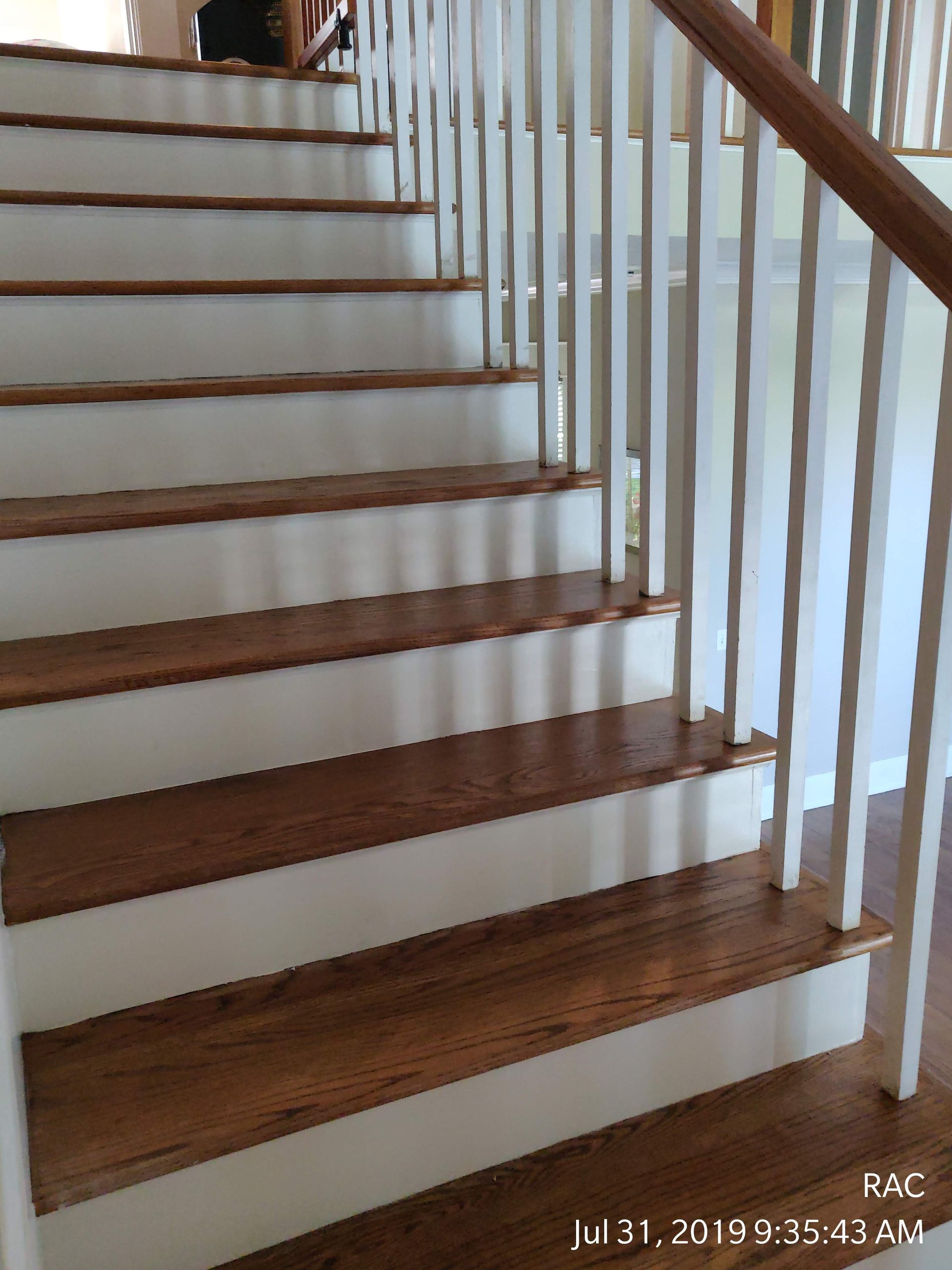 A set of stairs with wooden steps and white railings