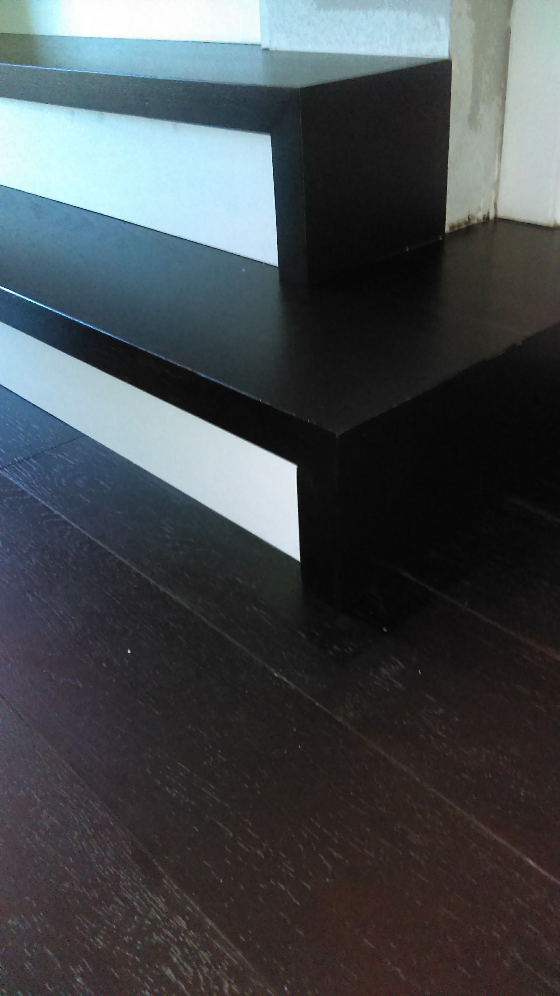 A black and white staircase with a wooden floor