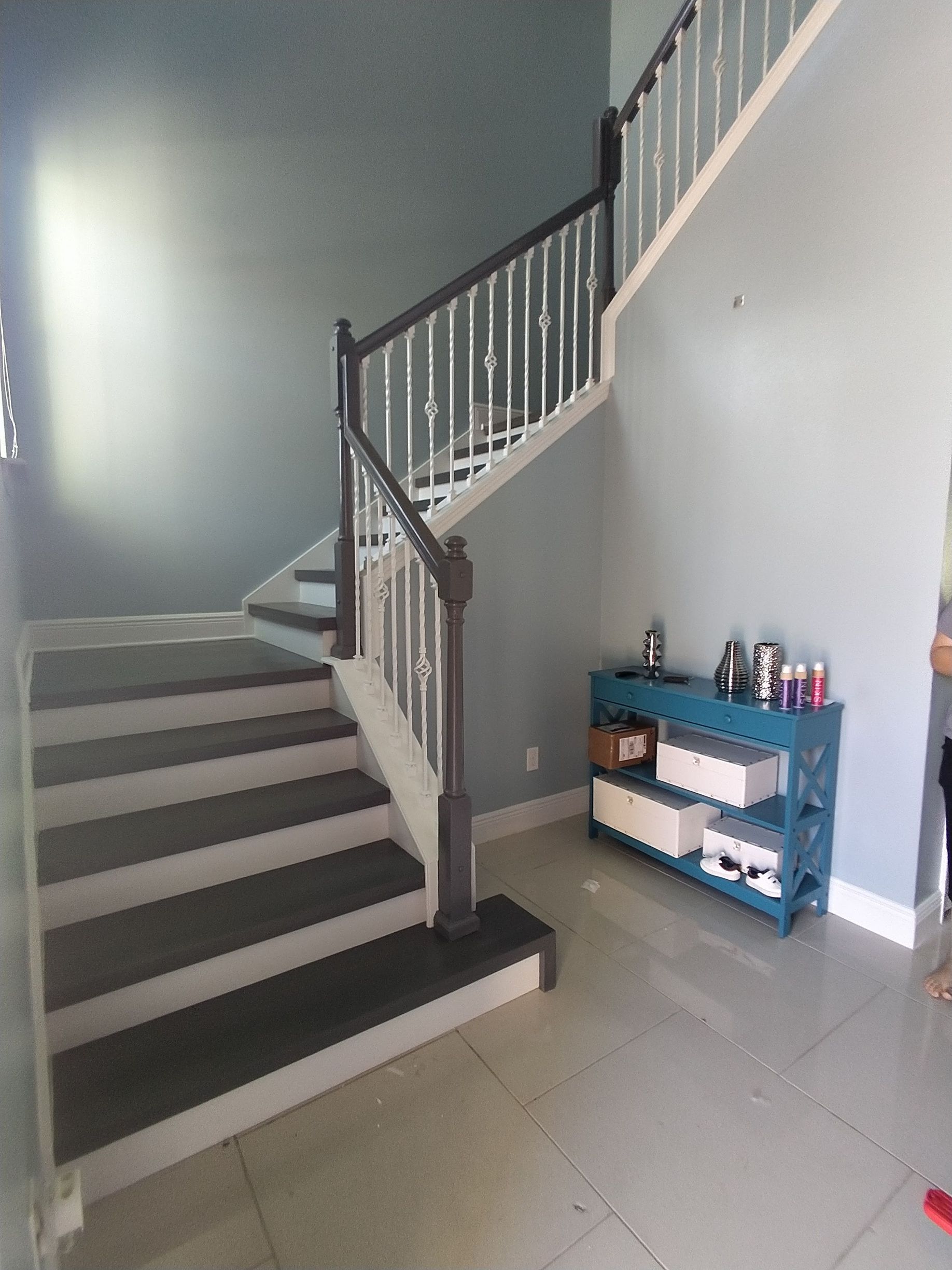A staircase in a house with a blue shelf next to it