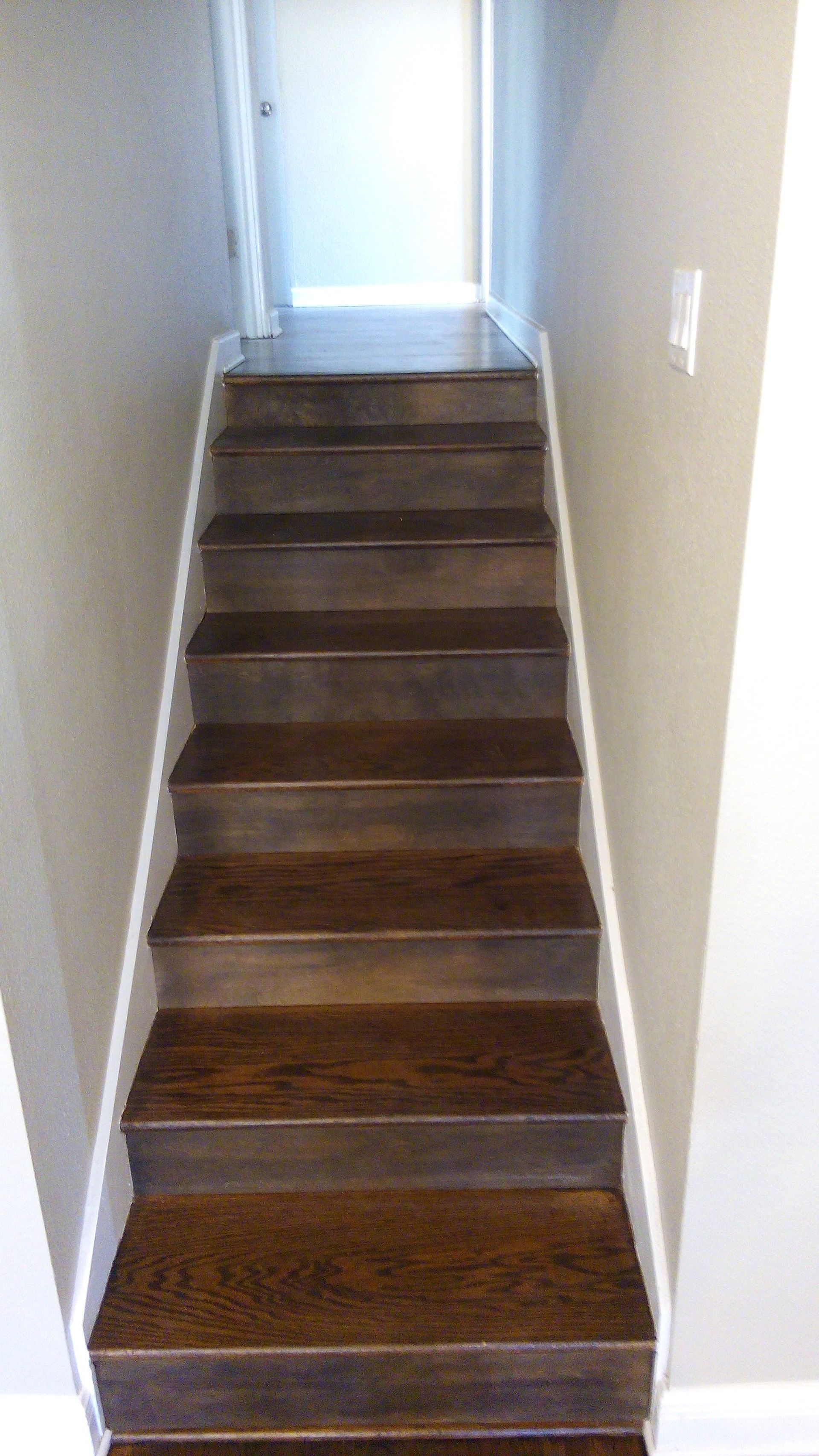 A set of wooden stairs leading up to a hallway in a house