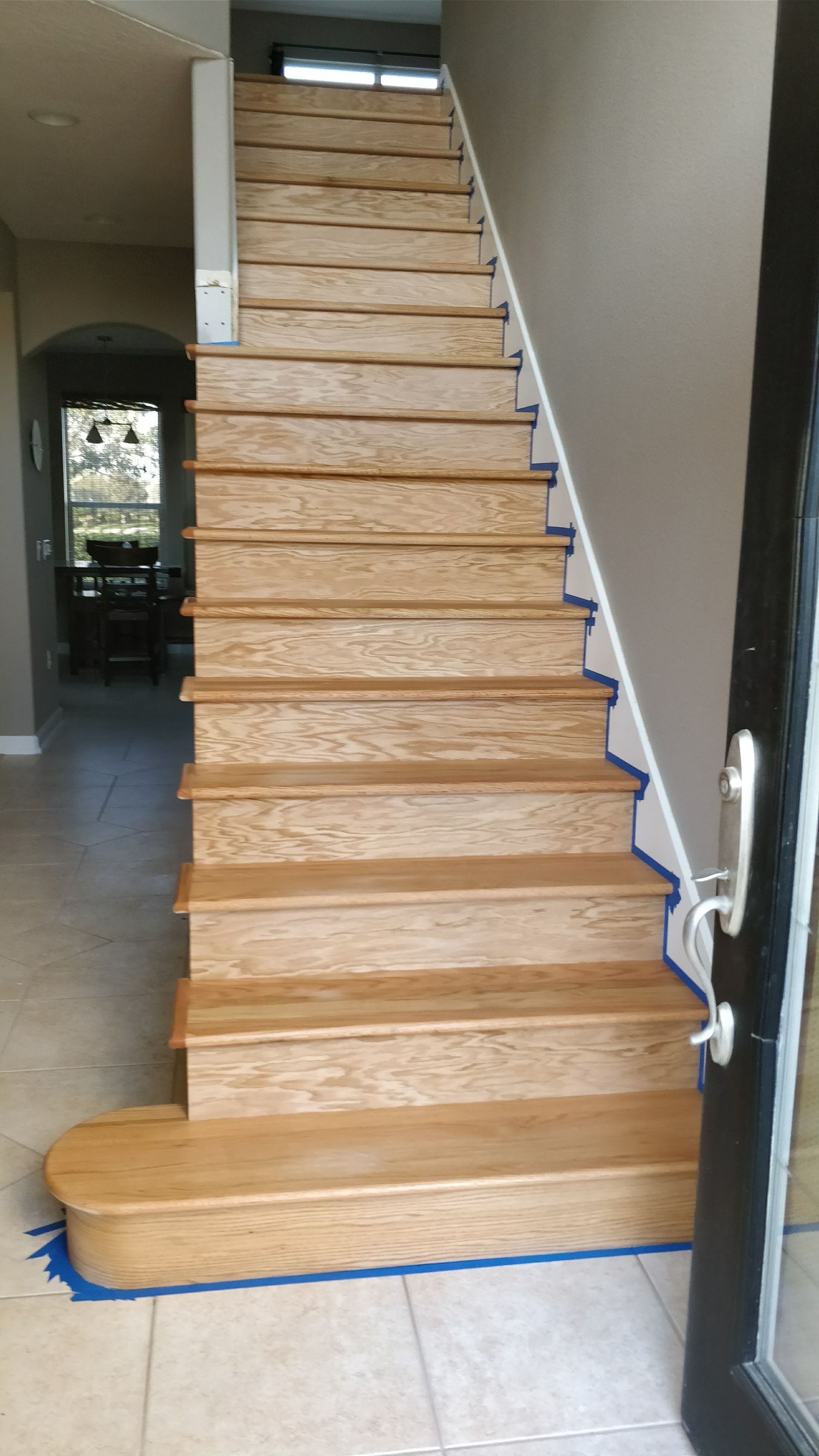 A wooden staircase is sitting in a hallway next to a door