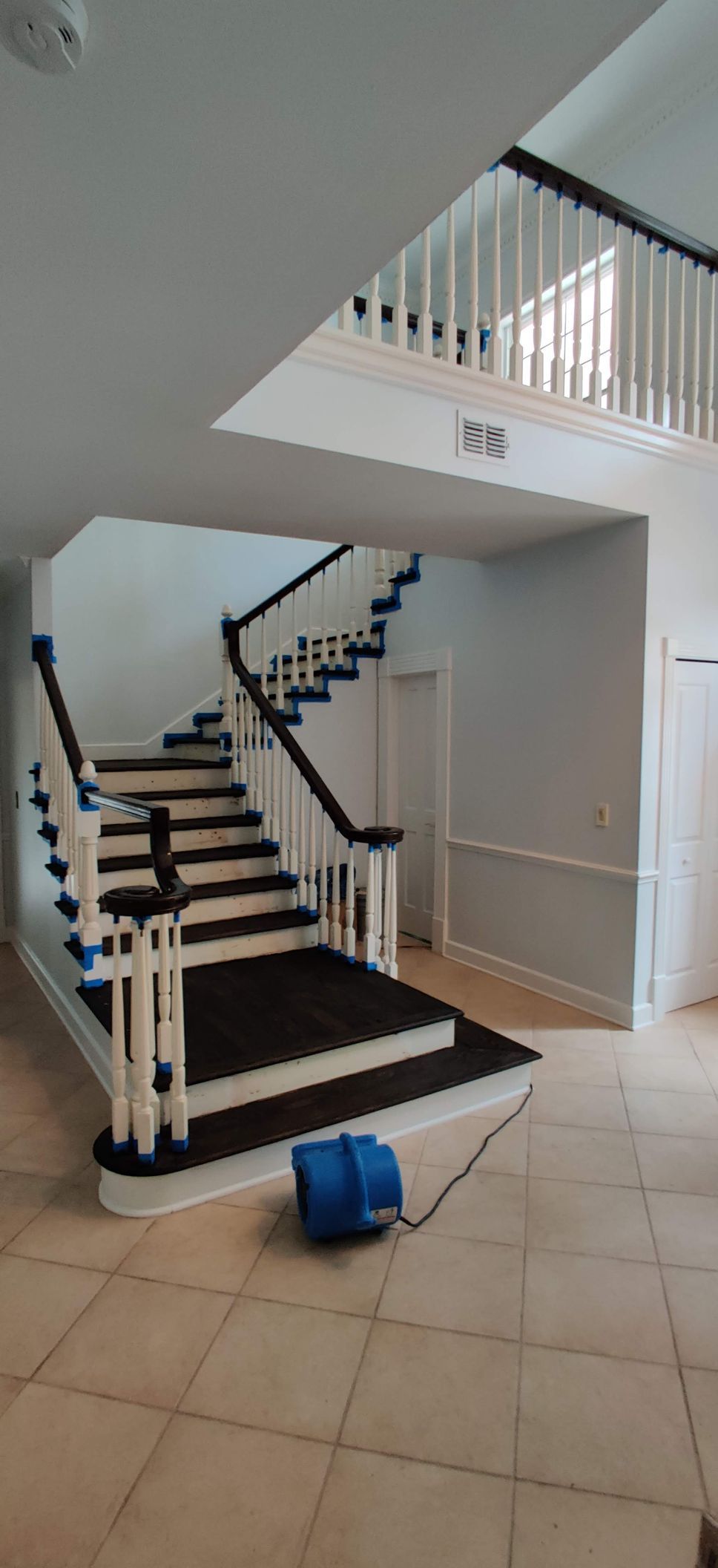 A large staircase in a house with a vacuum cleaner on the floor