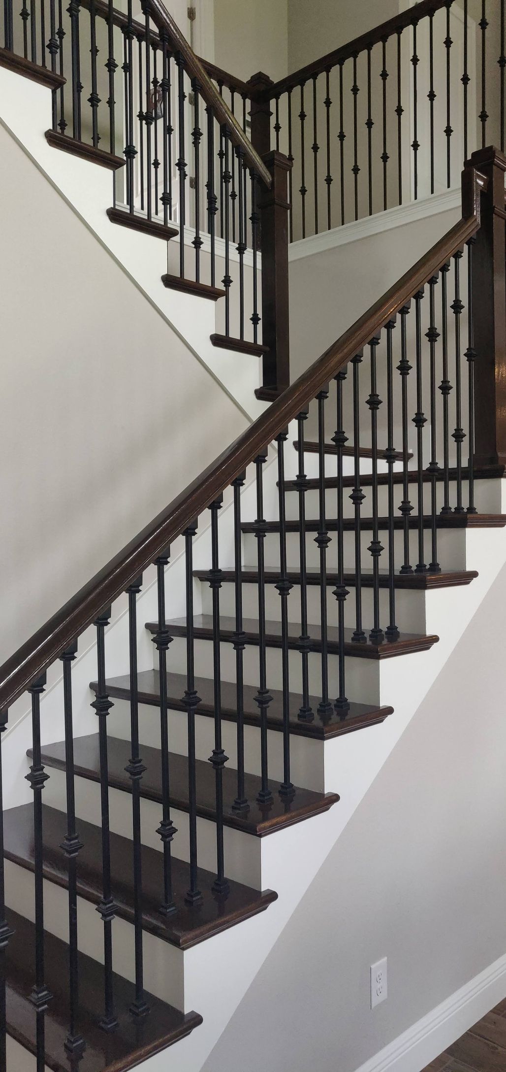 A staircase with a wrought iron railing and wooden steps