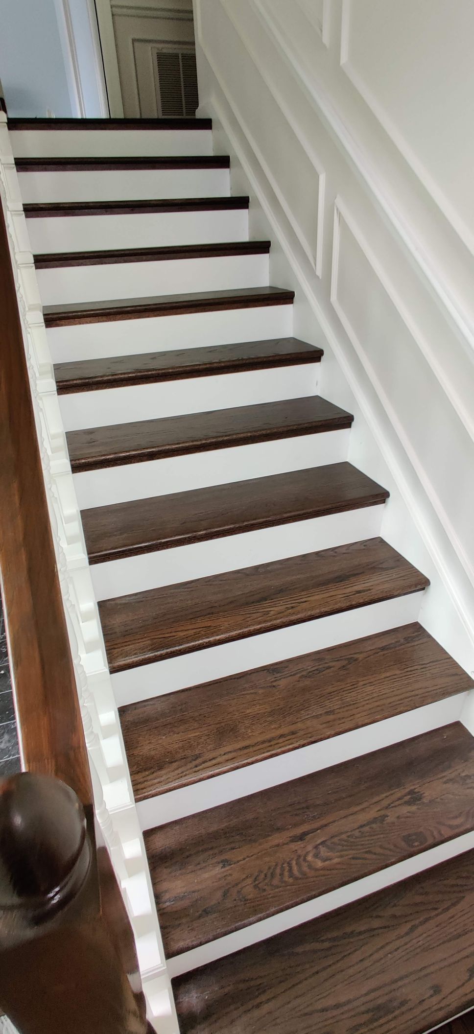 A staircase with wooden steps and white railing in a house