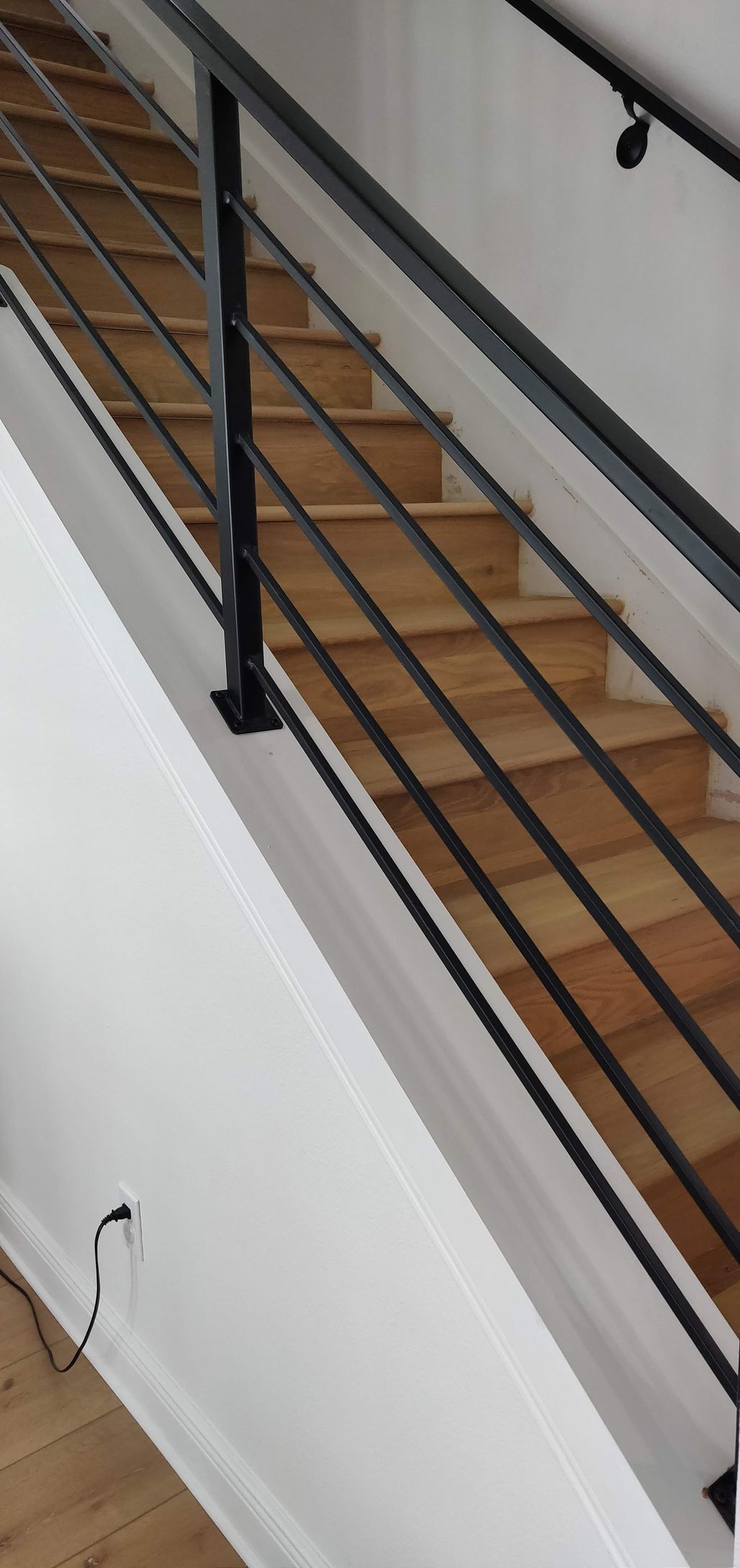 A staircase with a black railing and wooden steps