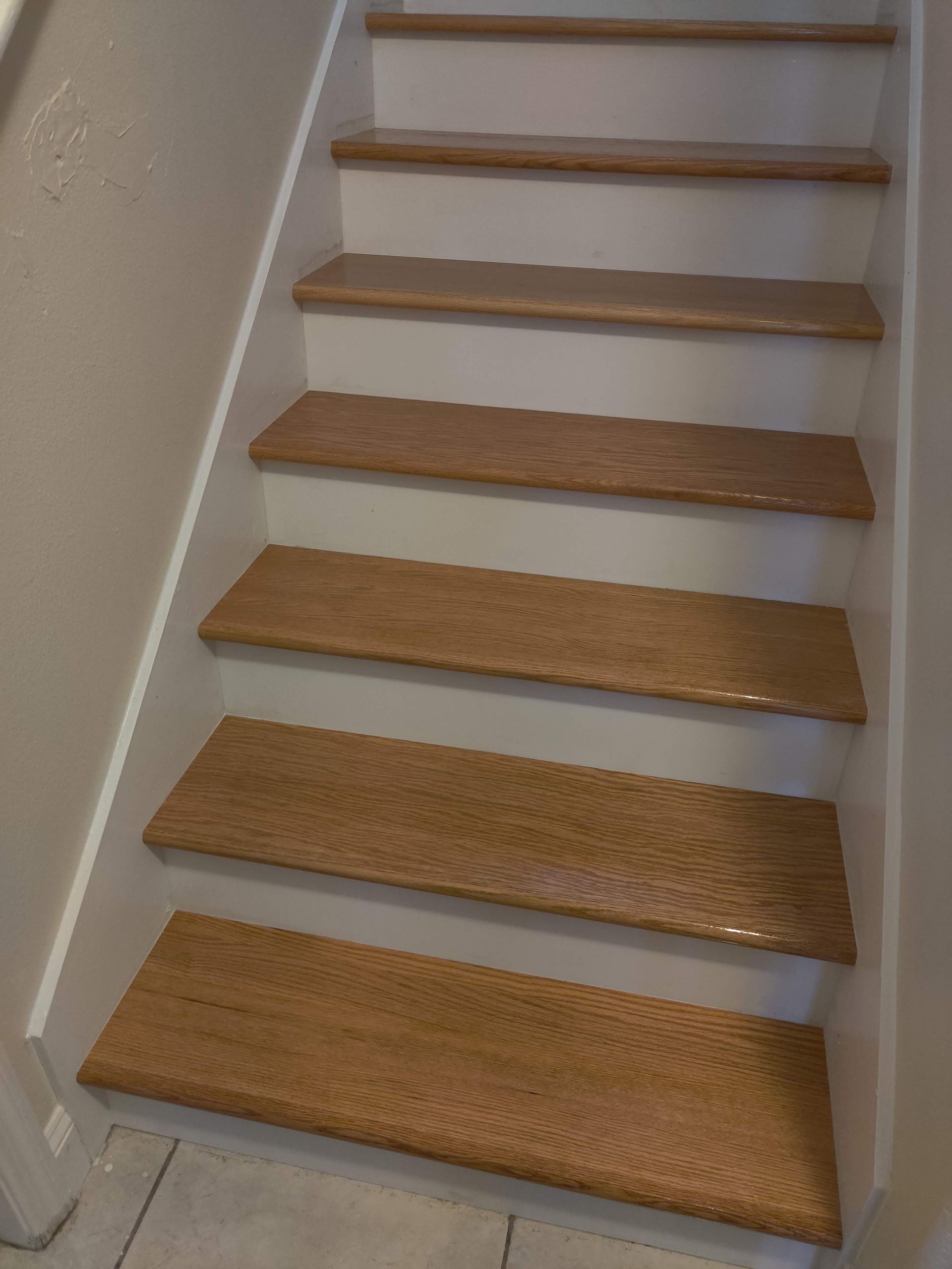A set of stairs with wooden steps and a white railing