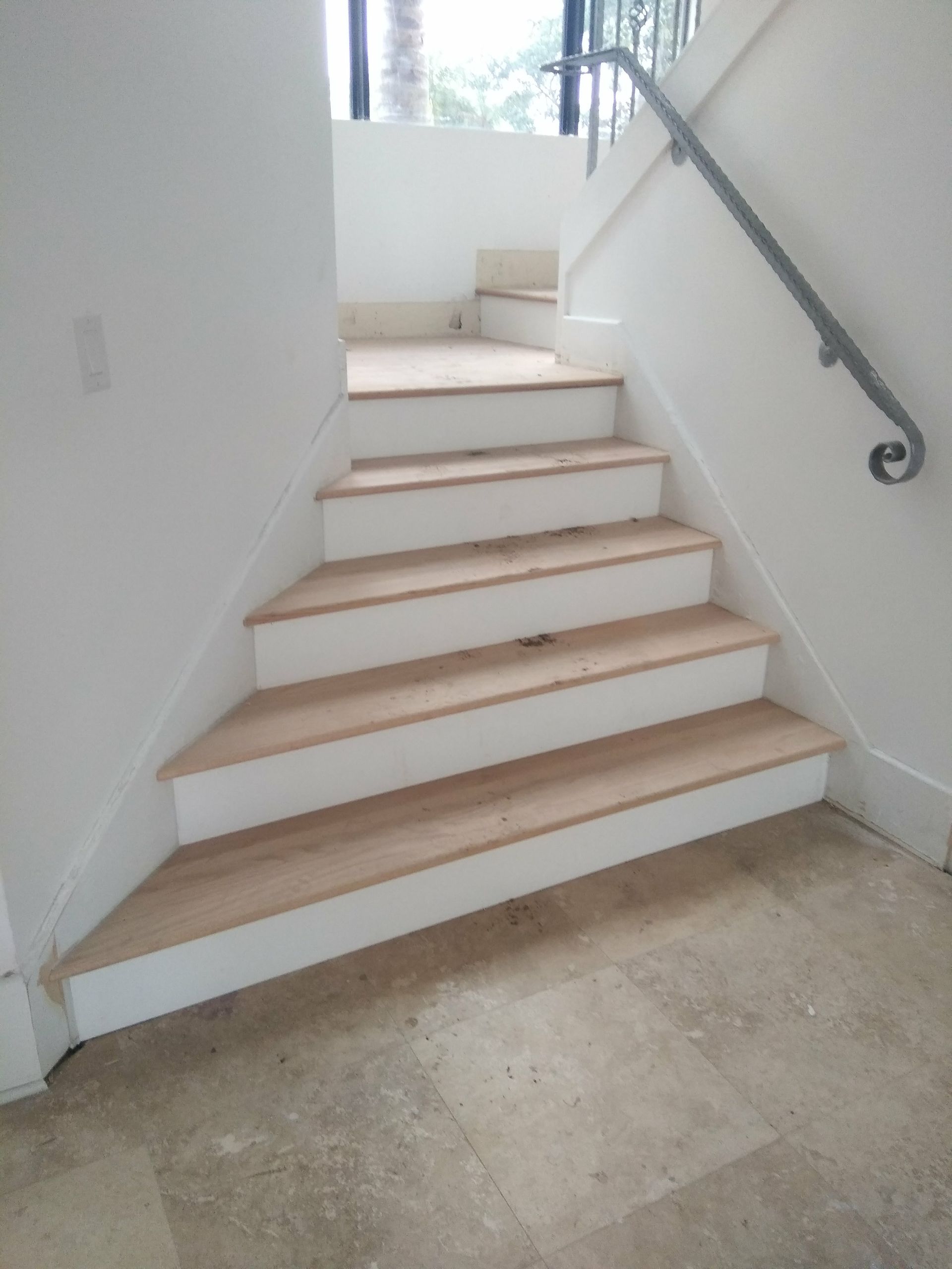 A white staircase with wooden steps and a metal railing