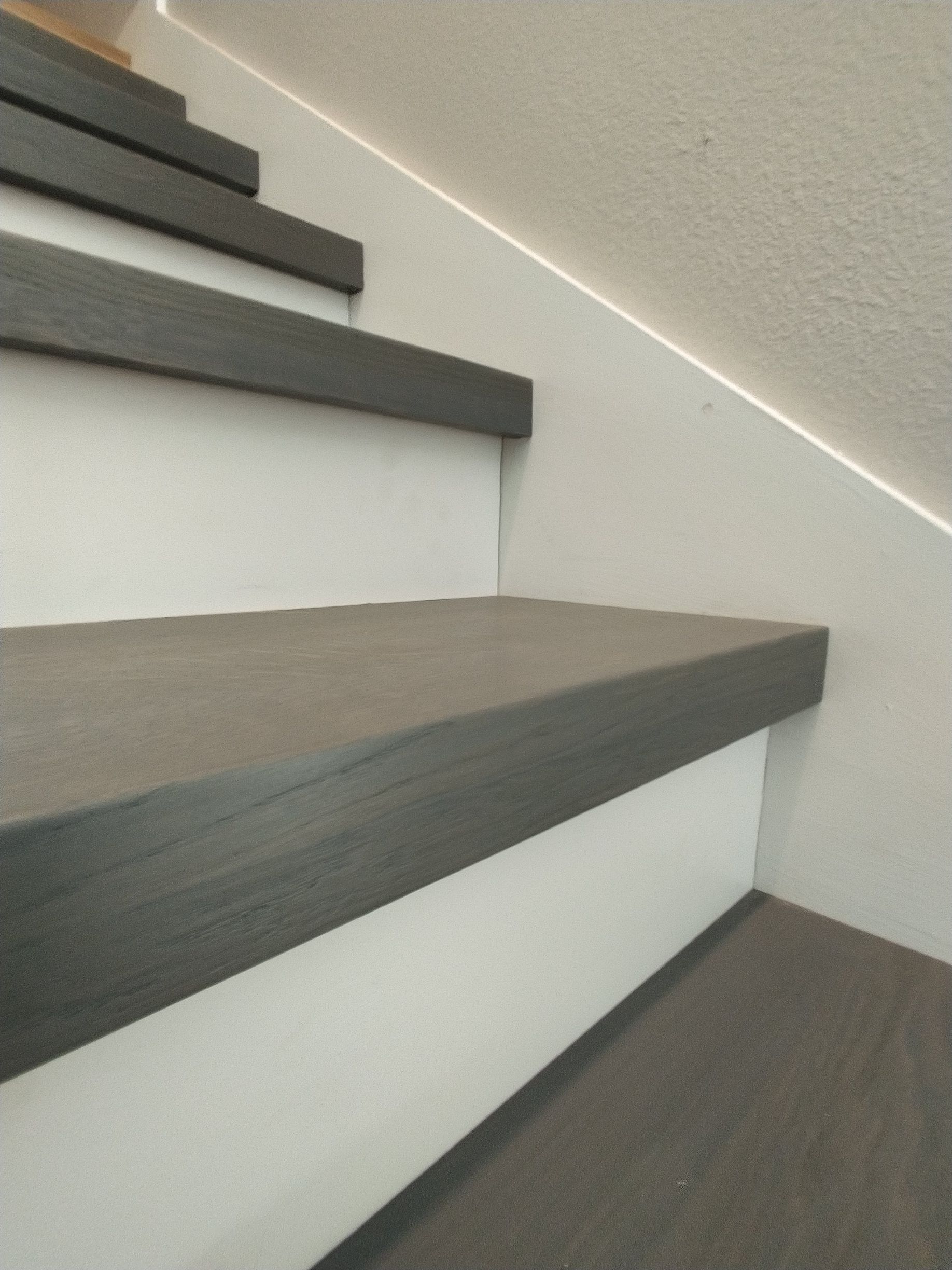 A set of stairs with a carpeted floor and a white wall