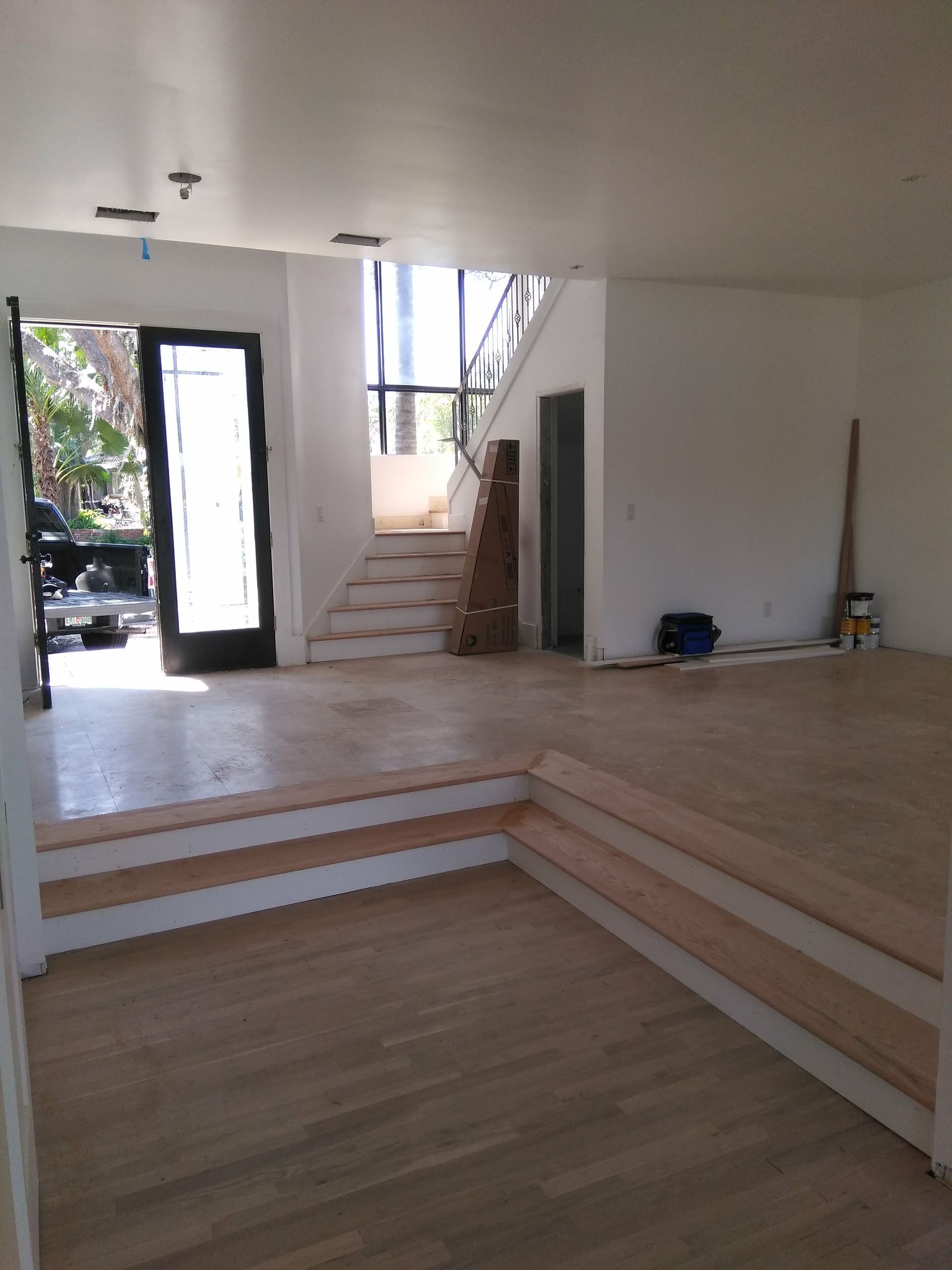 An empty room with wooden floors and stairs
