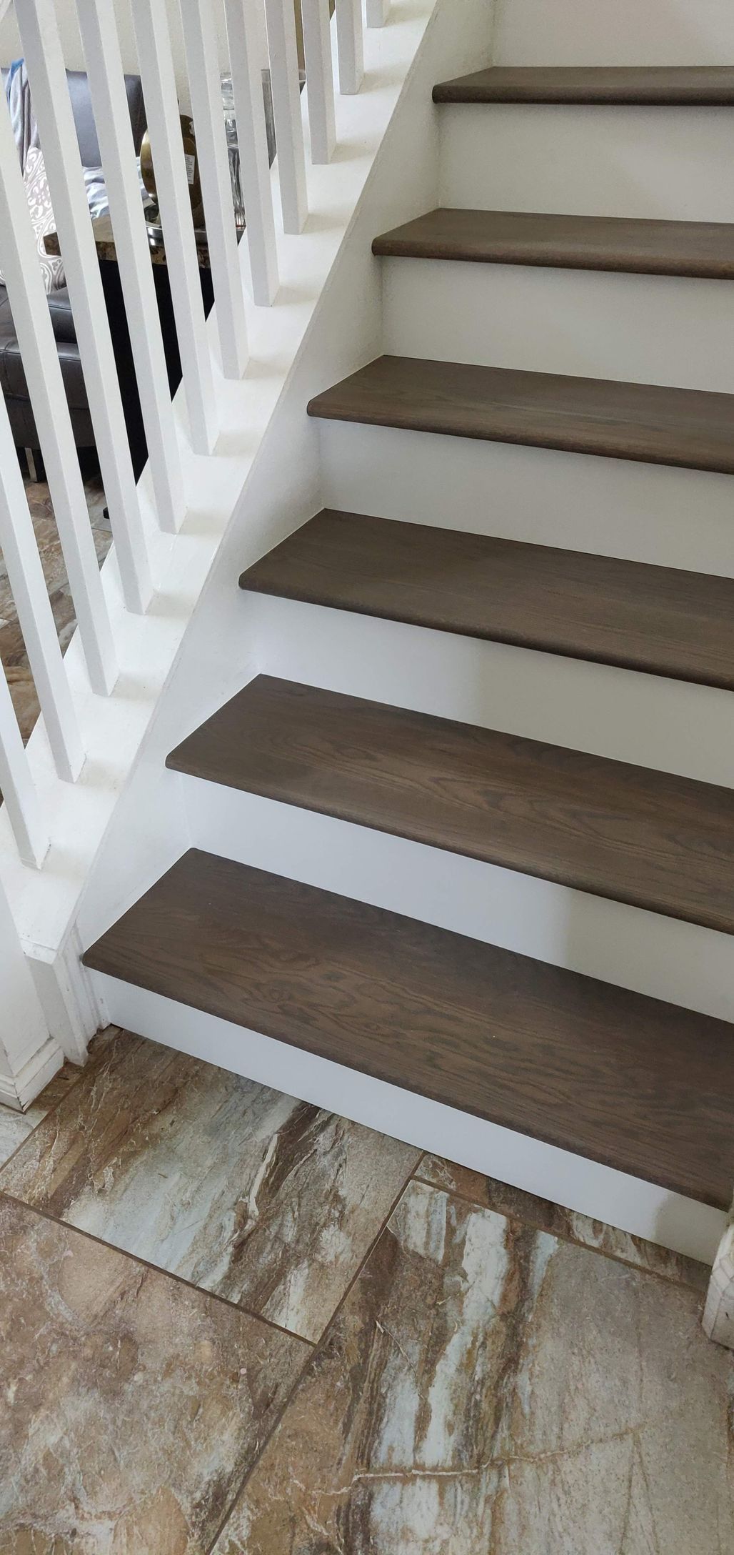 A close up of a set of stairs with wooden steps and a white railing