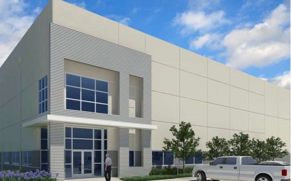 A white truck is parked in front of a large building